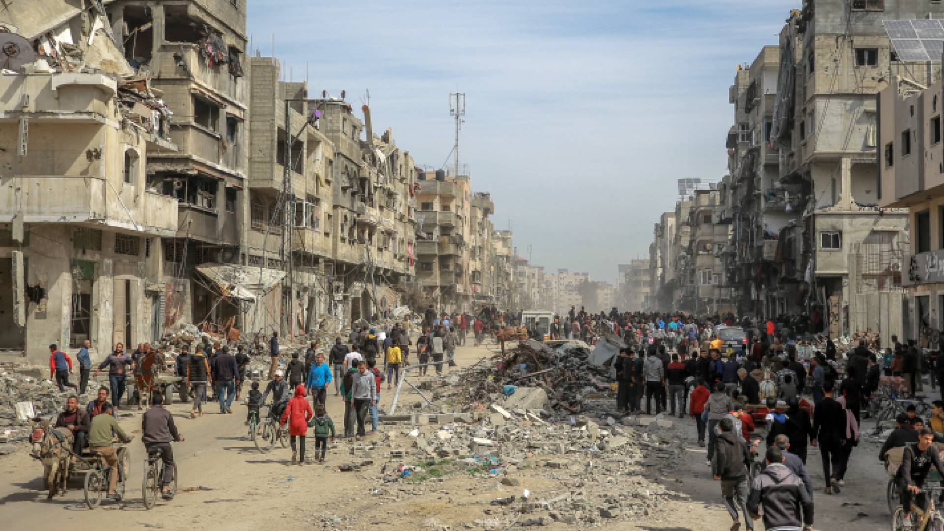 فلسطينيون يسيرون وسط الدمار في قطاع غزة