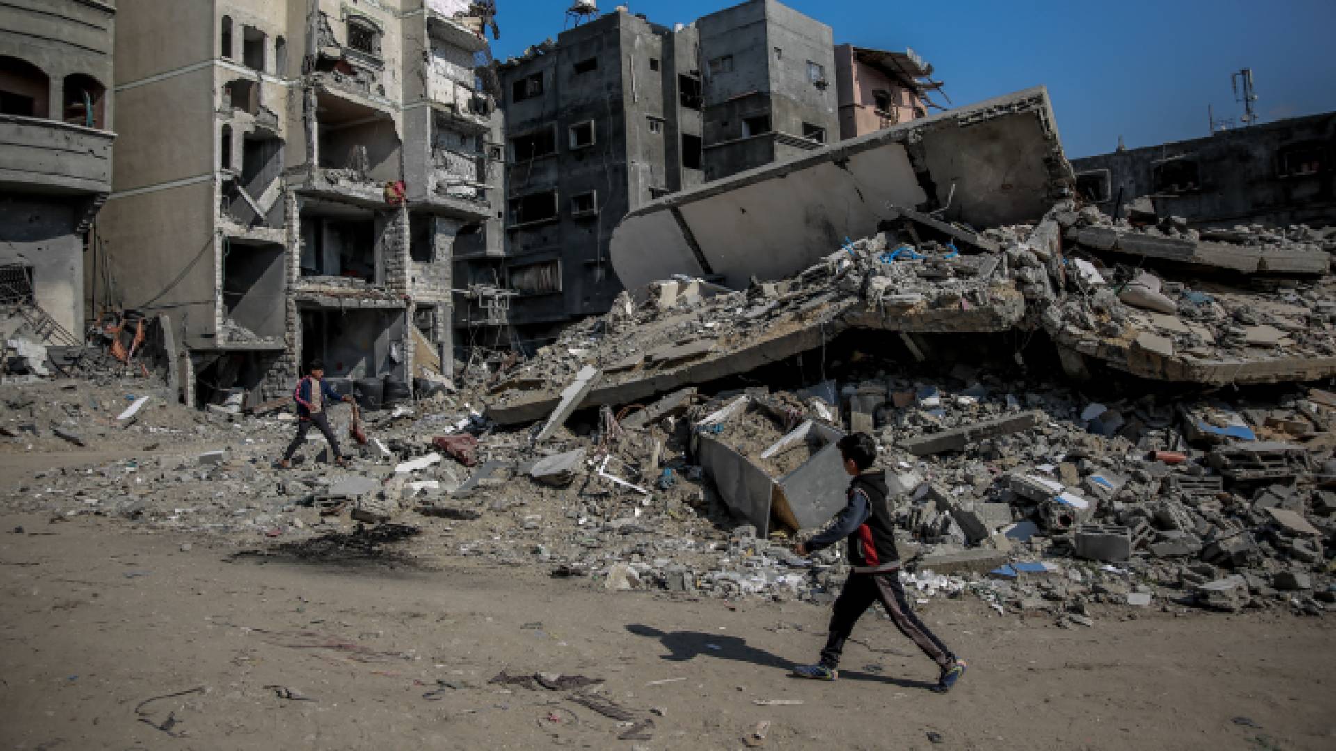 صغير يمشي بين ركام المنازل المدمرة في غزة
