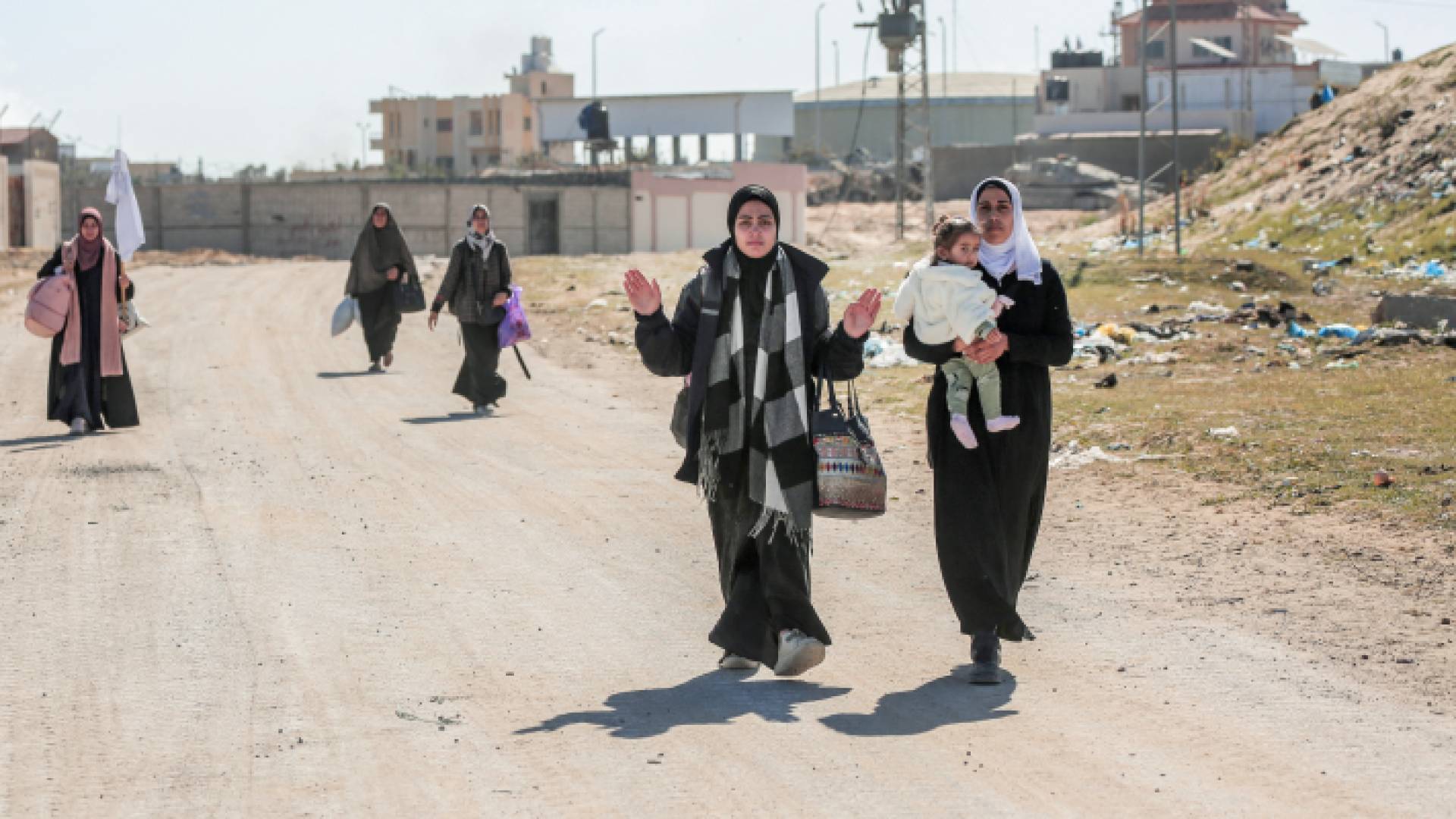 فلسطينيات نازحات يحملن أمتعتهن أثناء سيرهن أمام قوات الاحتلال في خان يونس جنوبي قطاع غزة