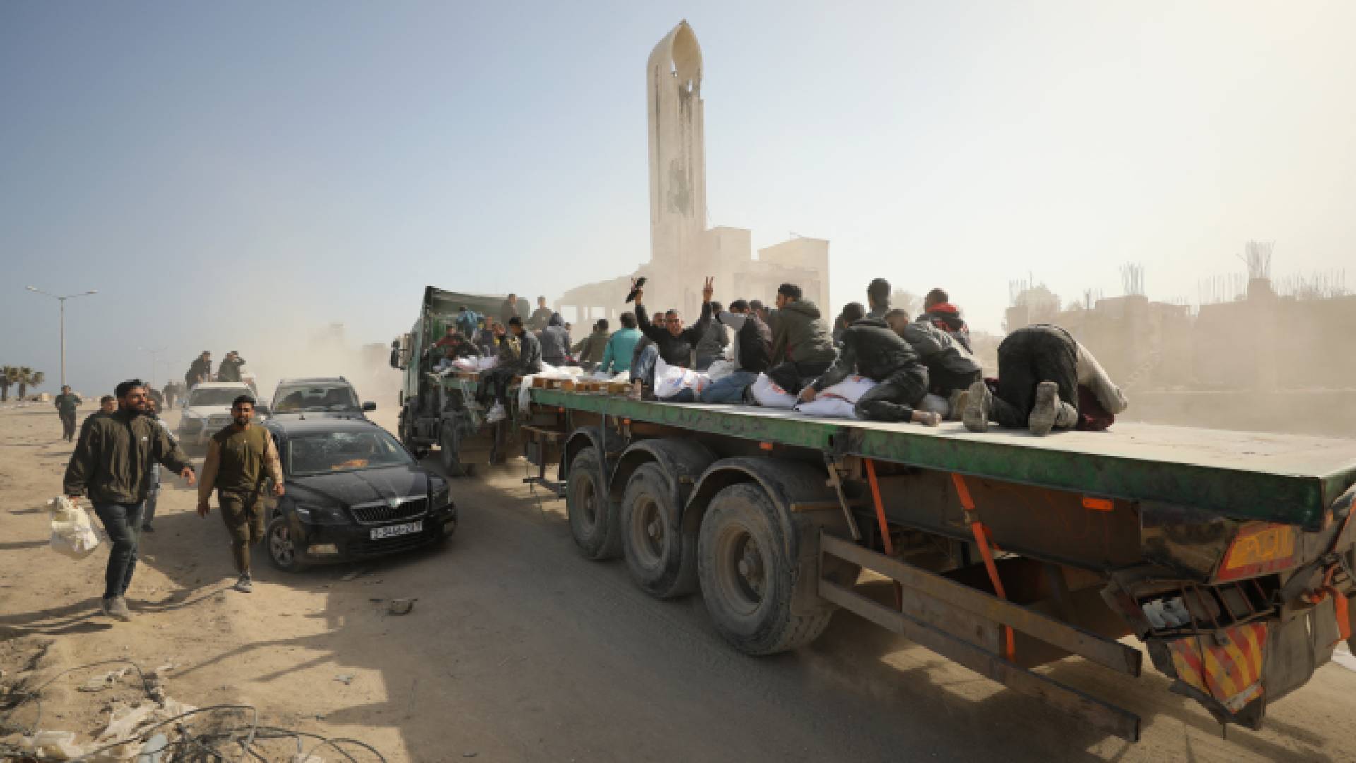 فلسطينيون ينقلون أكياس الطحين على ظهر شاحنات في غزة - AFP