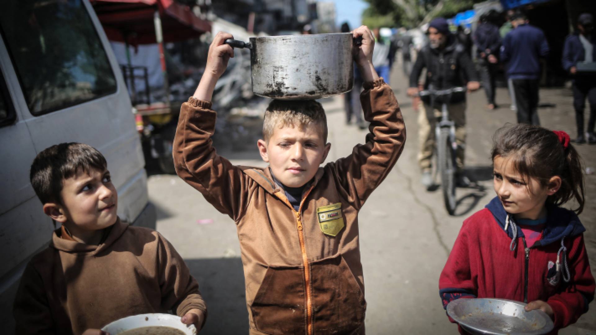 أطفال غزيون يحملون أوعية فارغة للبحث عن القليل من الطعام "أ ف ب"