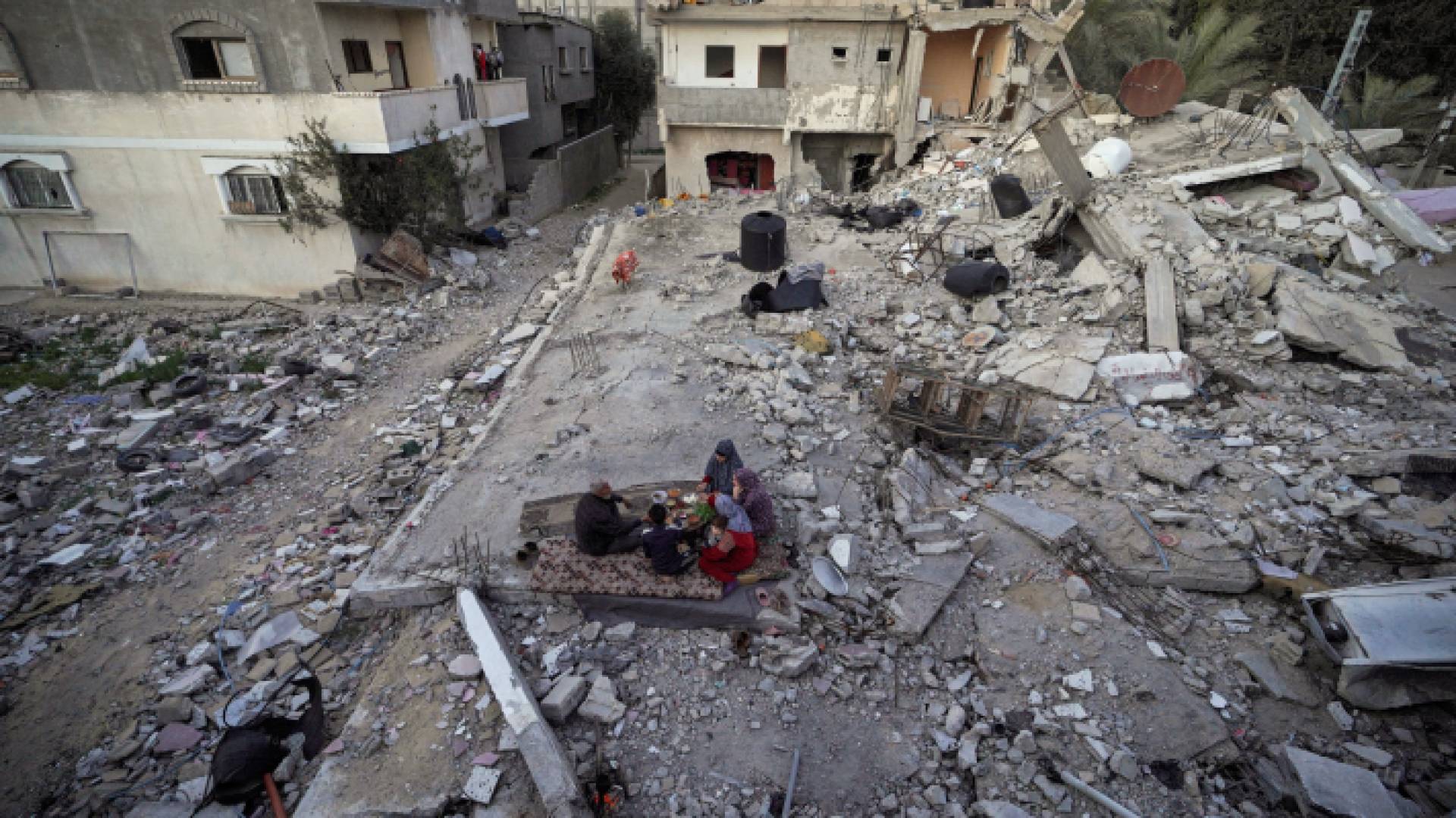 عائلة فلسطينية تتناول وجبة الإفطار وسط أنقاض منزلها - AFP