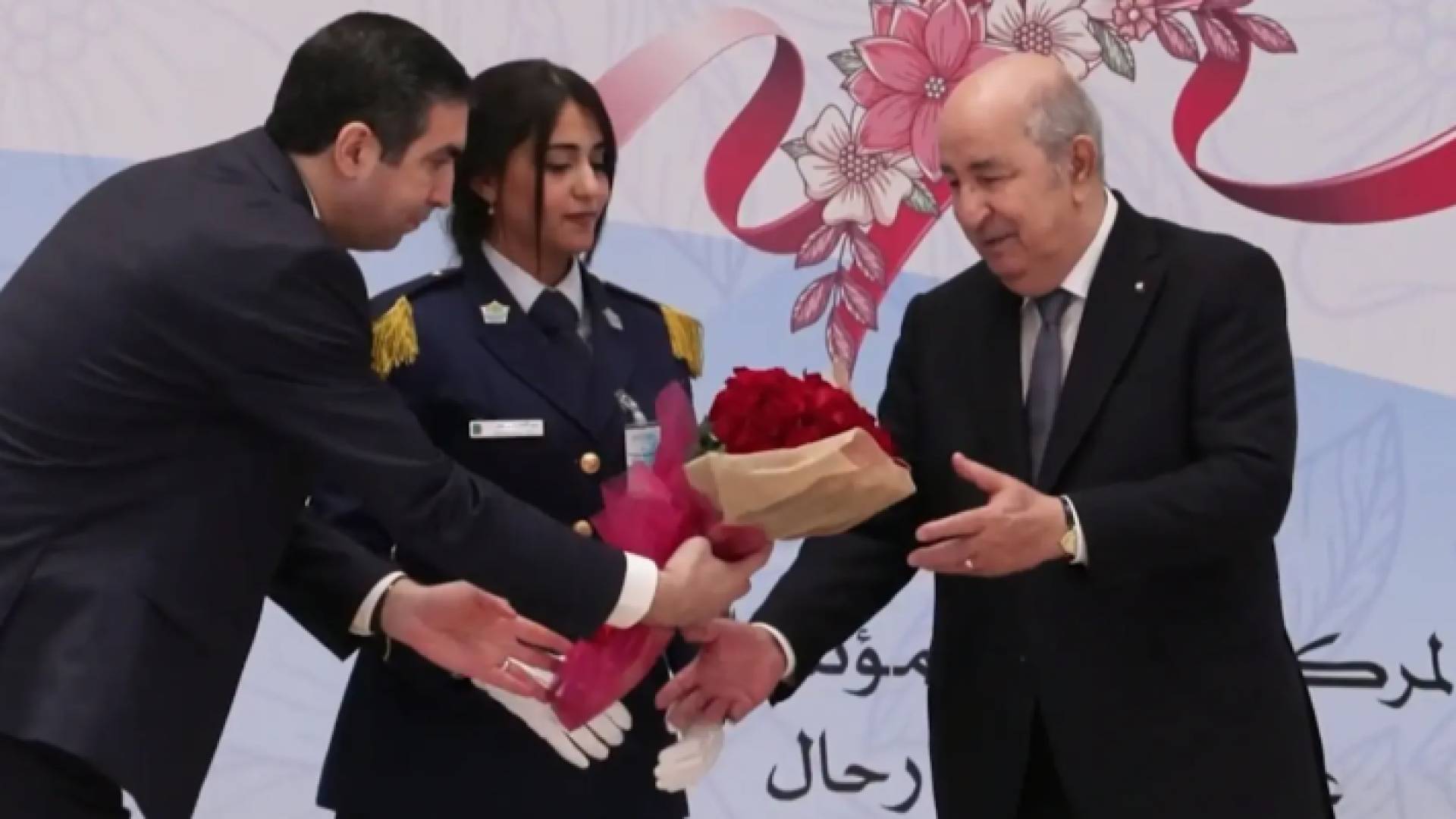 خلال تسليم الرئيس الجزائري عبد المجيد تبون باقة ورد لإحدى السيدات في احتفال بعيد المرأة