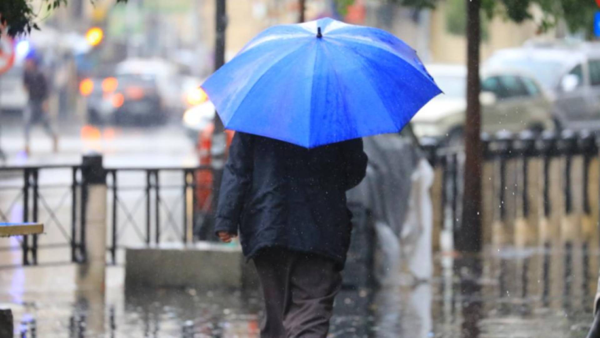 رجل يسير وسط أجواء ماطرة