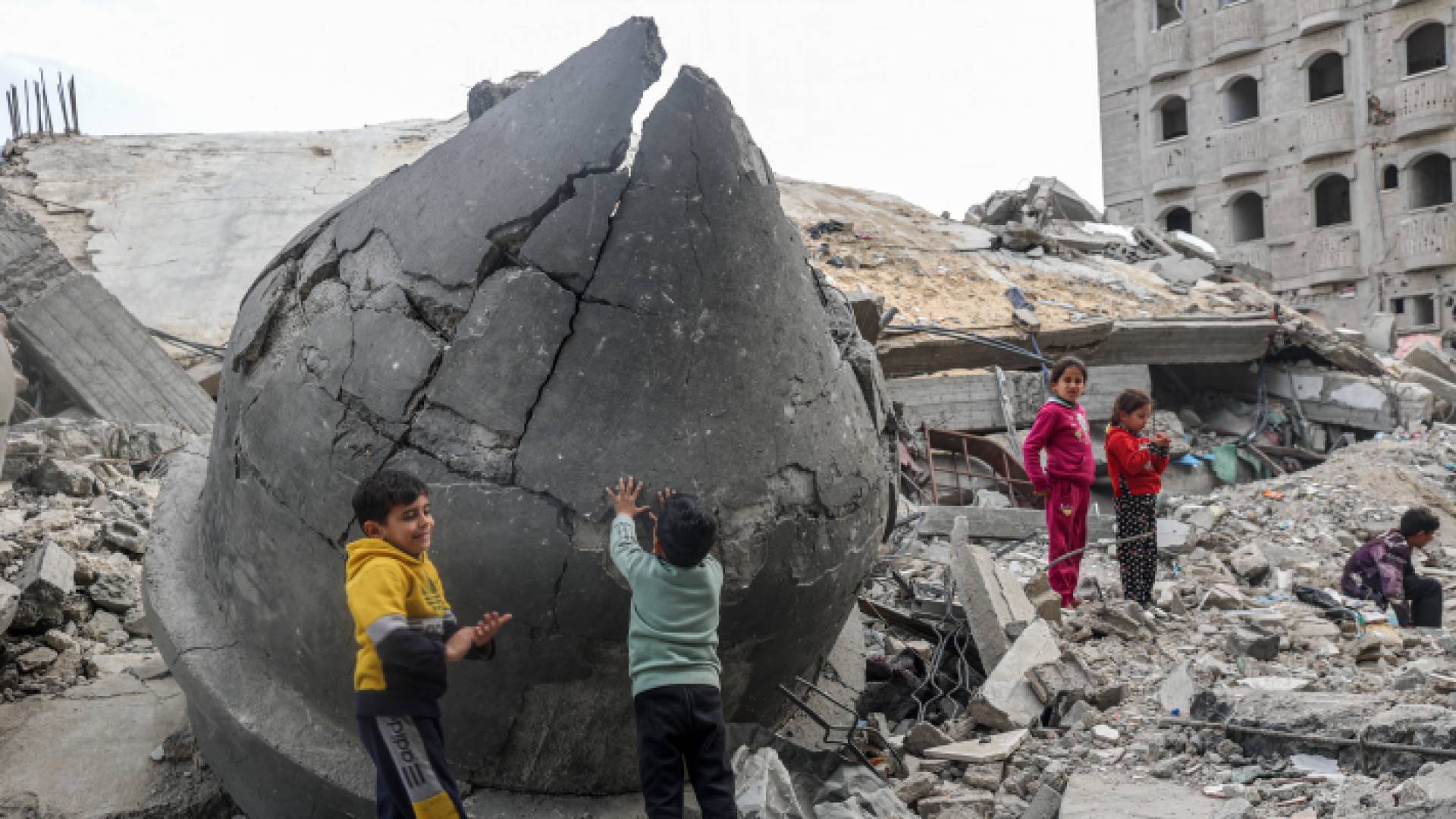 طفال يلعبون على أنقاض مسجد الفاروق الذي دمر خلال قصف الاحتلال - AFP