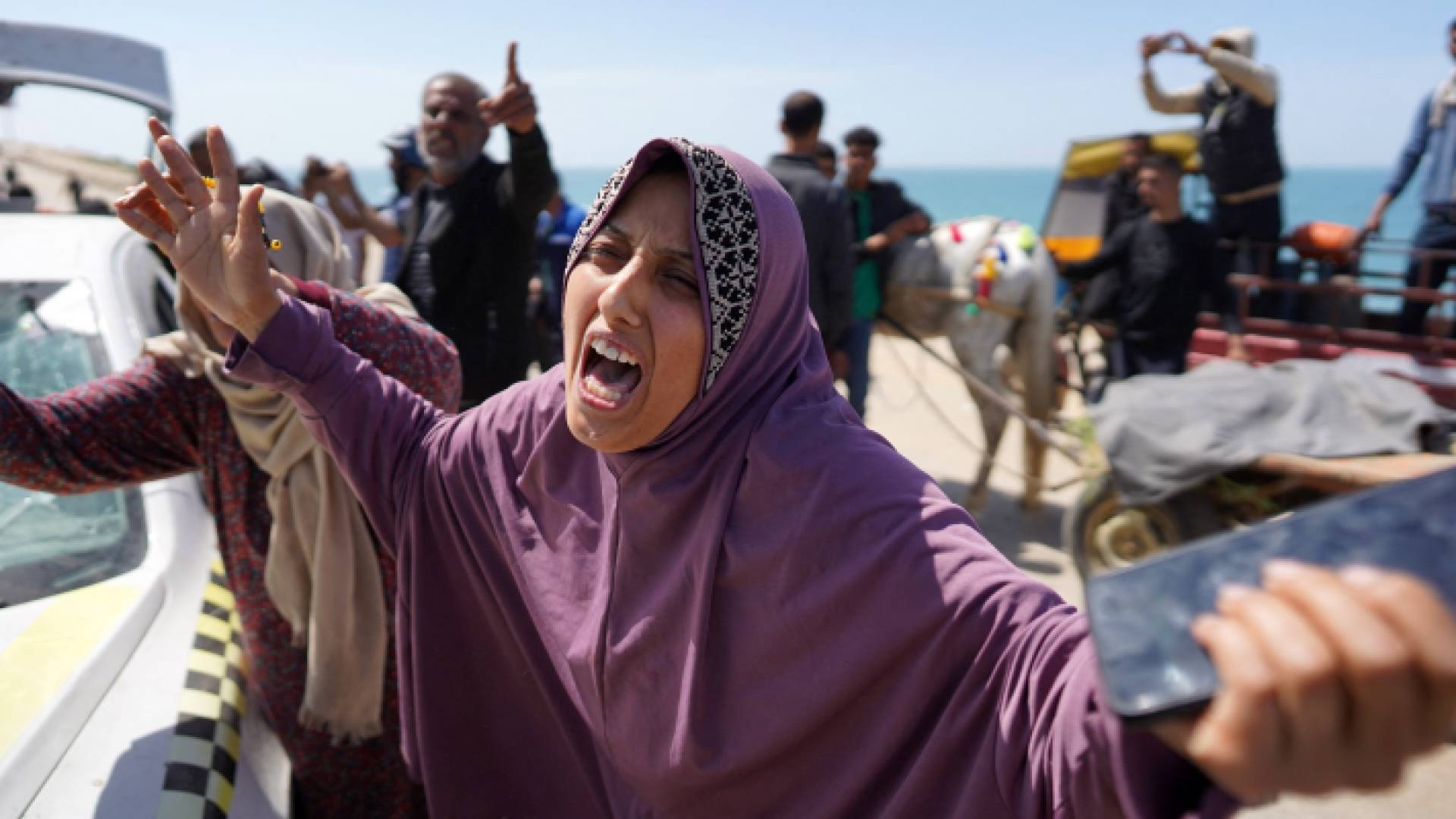 رد فعل فلسطينية على رؤية جثث أقاربها الذين قتلوا في القصف الإسرائيلي وسط قطاع غزة - AFP