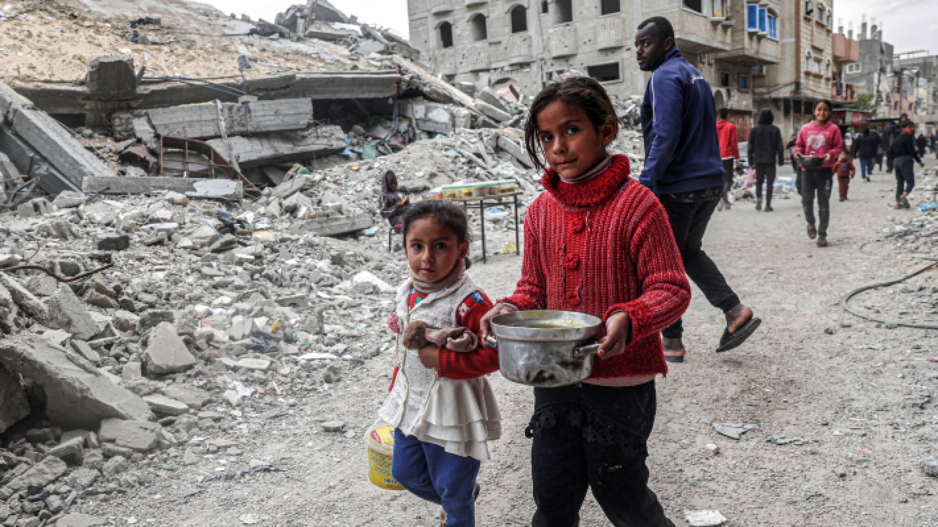 فلسطينيون عقب تلقي وجبات غذائية