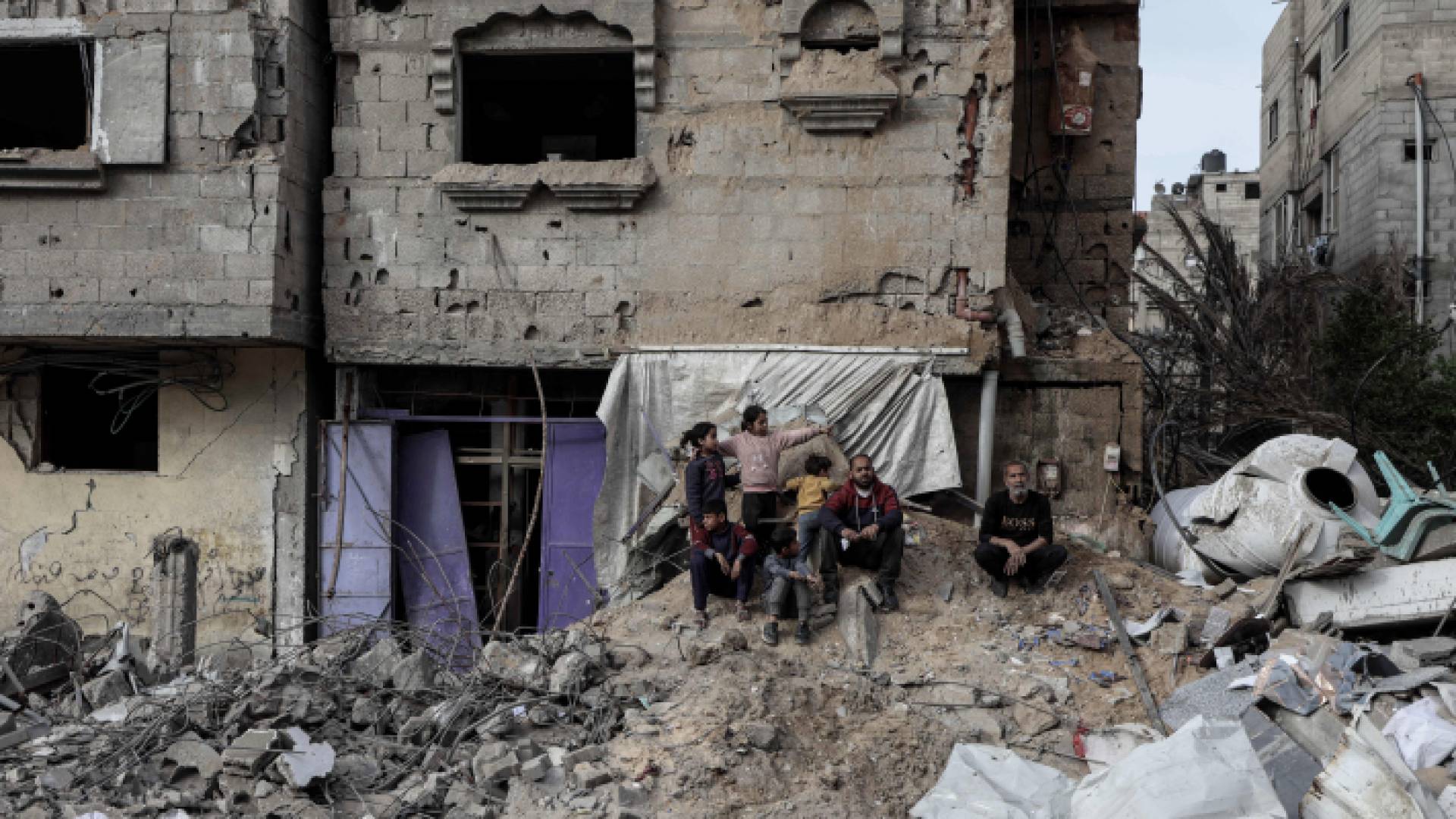 فلسطينيون يجلسون وسط الأنقاض بعد قصف الاحتلال رفح جنوبي قطاع غزة