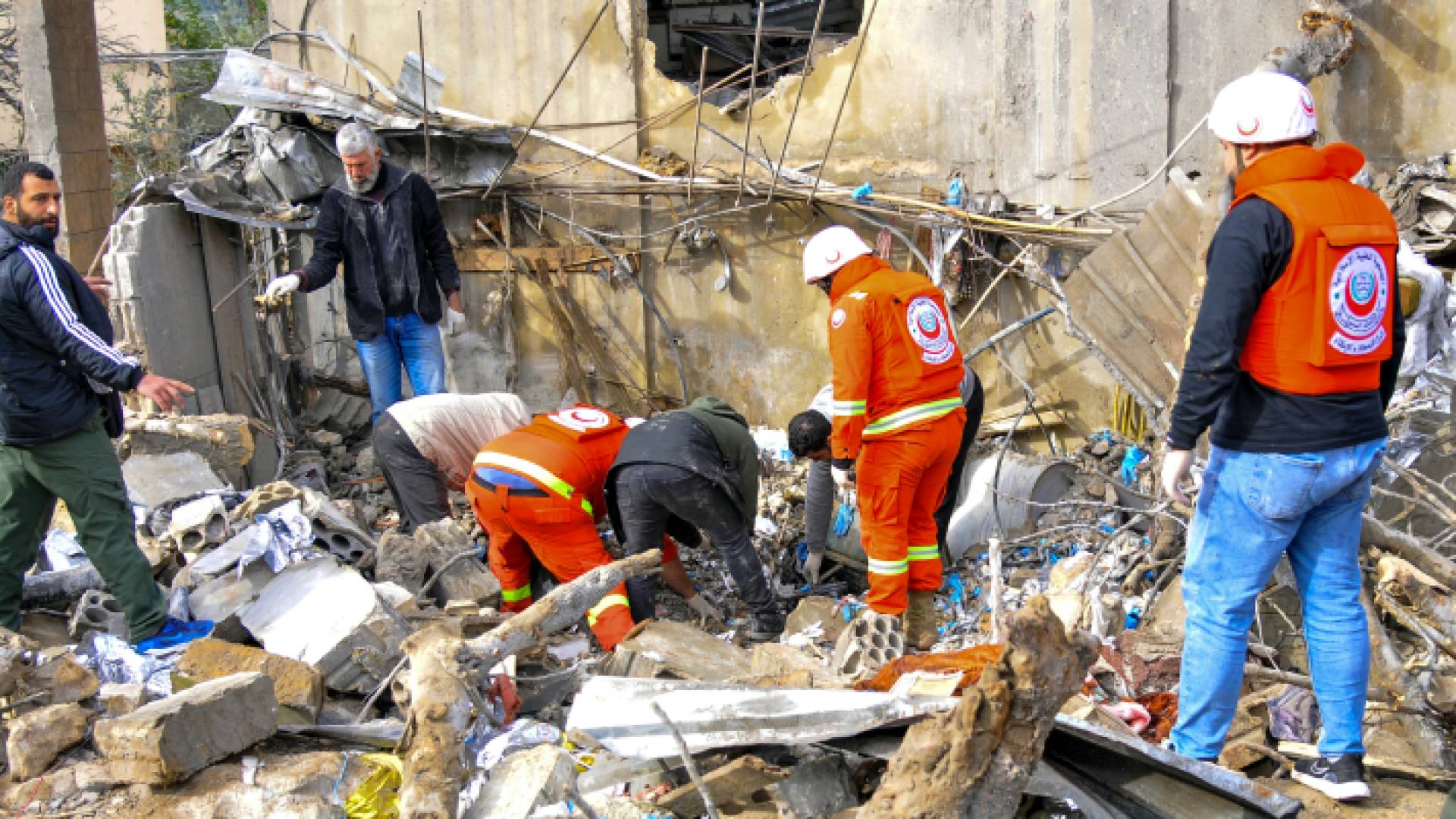 مسعفون يتفقدون الدمار في موقع غارة جوية للاحتلال في الهبارية