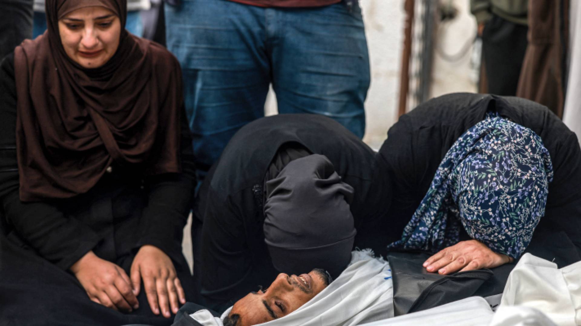 نساء يبكين على جثة قريبهن الذي استشهد أثناء القصف الإسرائيلي لرفح - AFP