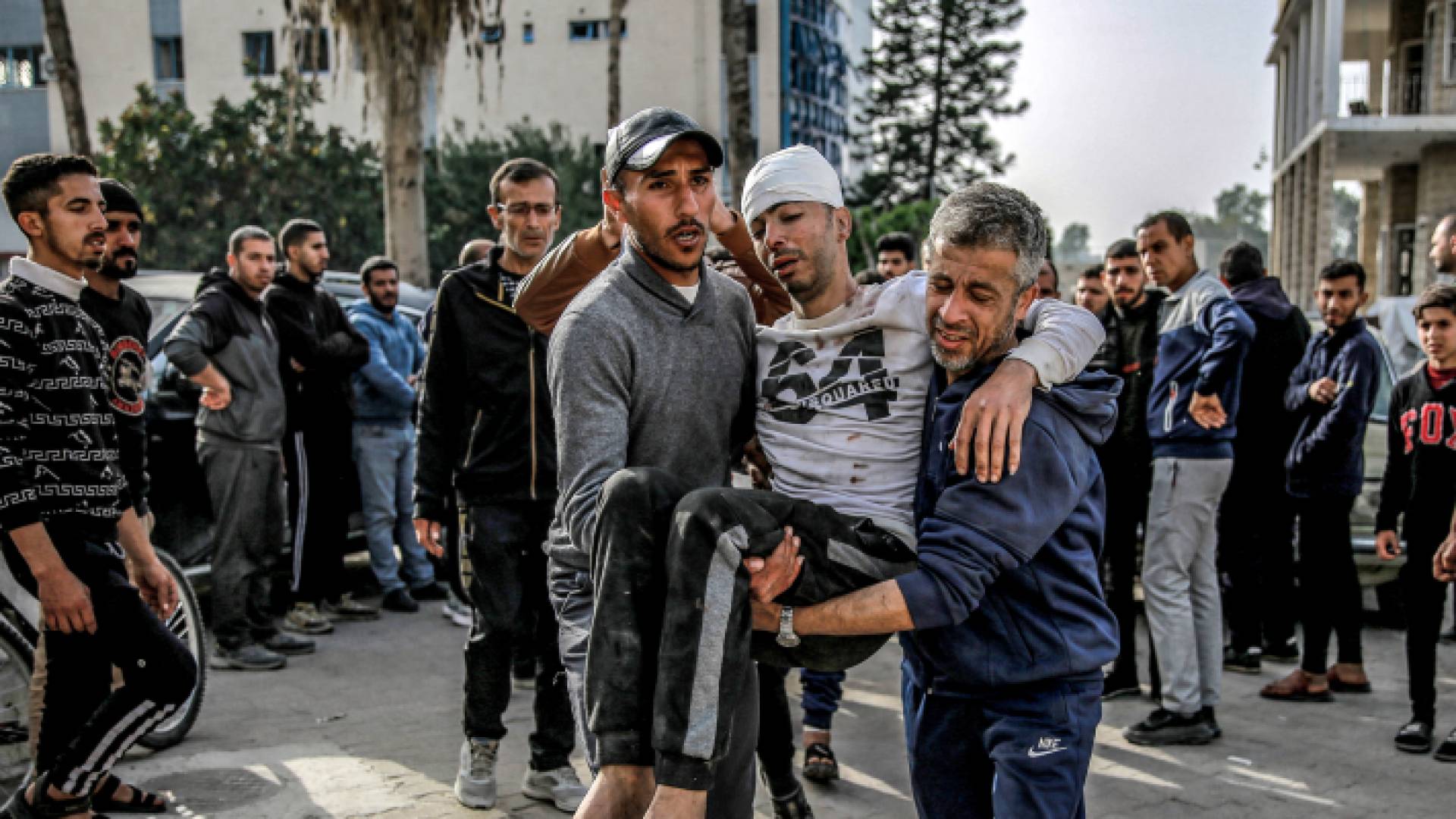 فلسطينيان يحملان مصابا في مدينة غزة - AFP