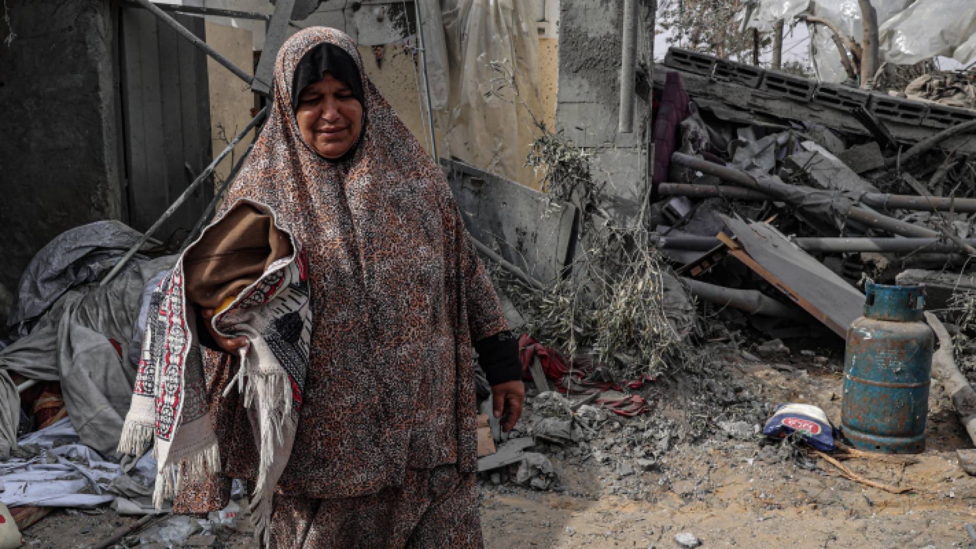 فلسطينية تتفقد الأضرار التي لحقت بمبنى بعد القصف الإسرائيلي على رفح جنوبي قطاع غزة