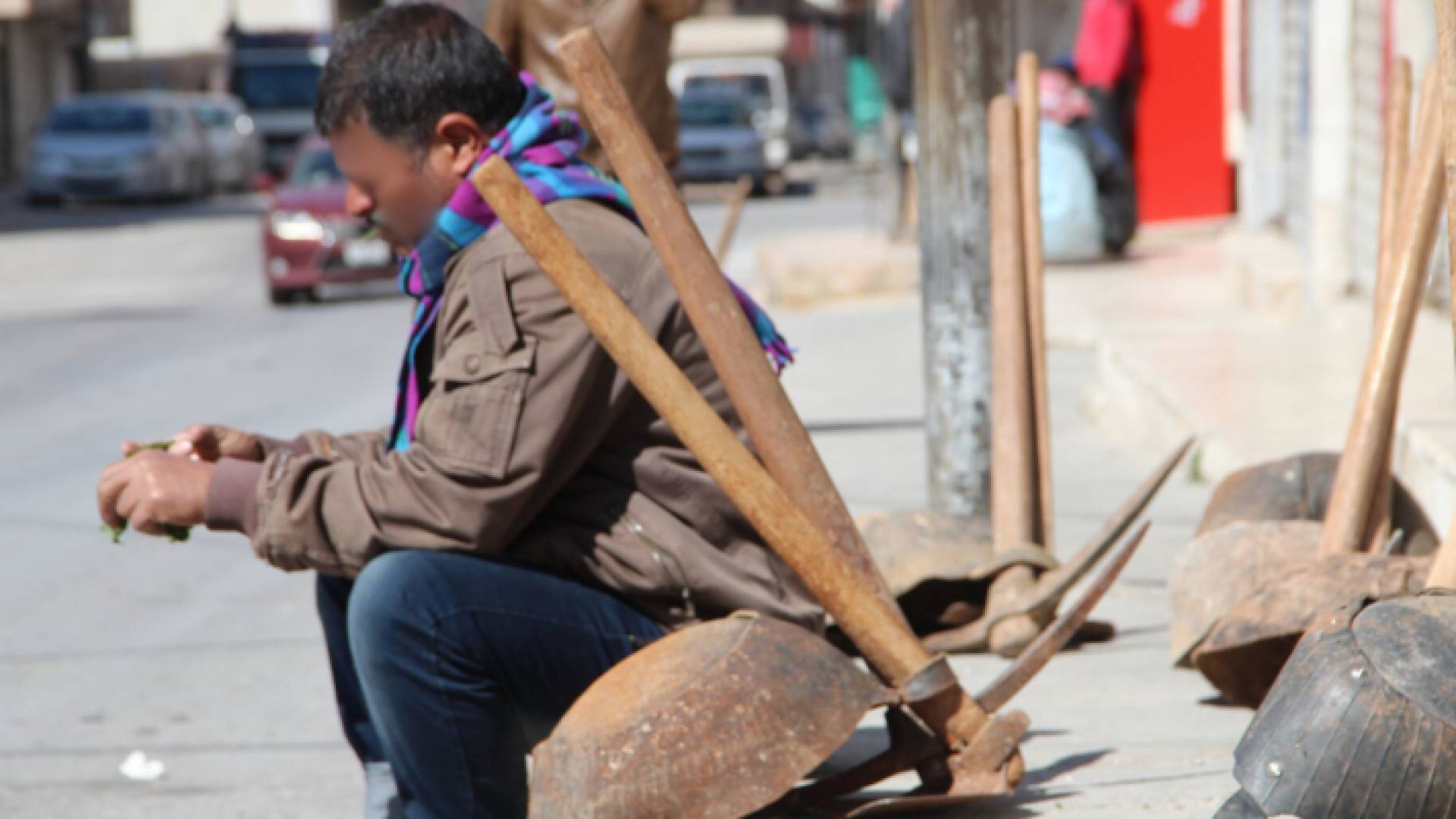 عامل وافد يجلس على رصيف أحد الشوارع في الأردن
