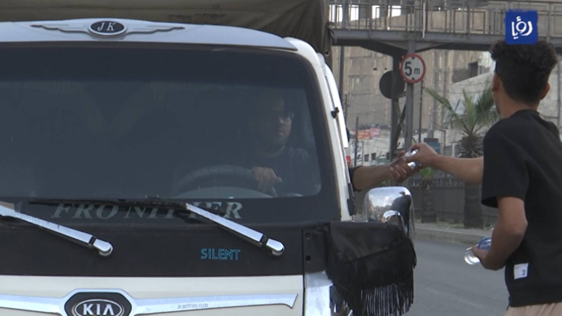 شاب يقوم بتوزيع المياه والتمور على المواطنين في الشوارع