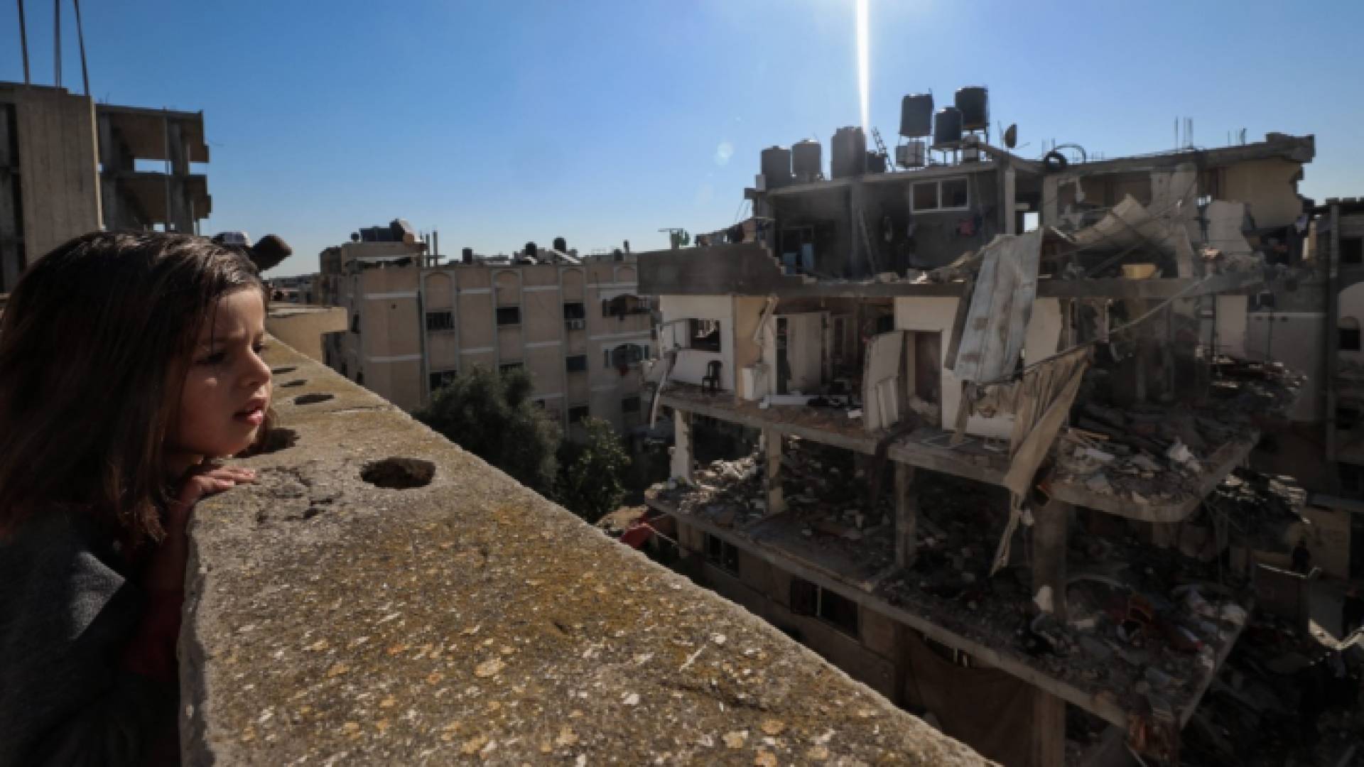 صغيرة فلسطينية تظر لآثار الدمار في غزة "أ ف ب"