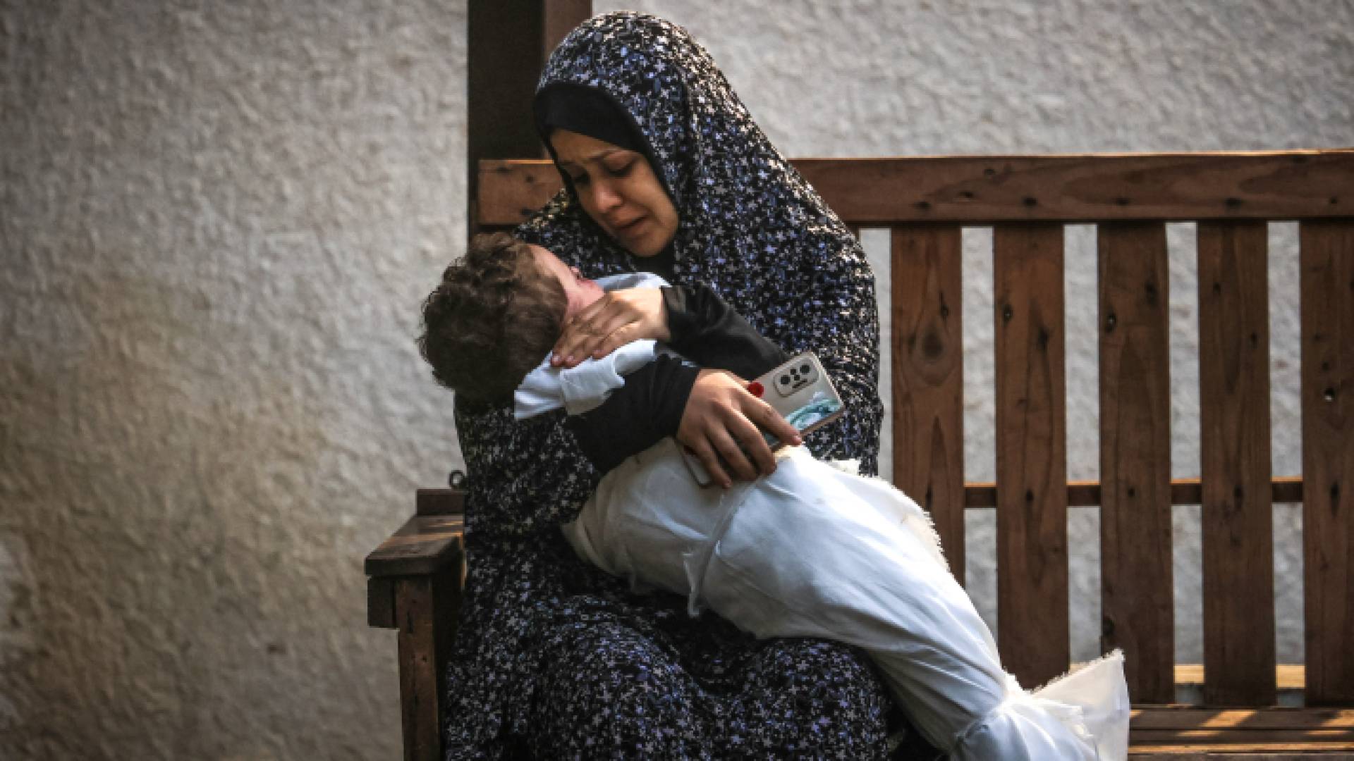 فلسطينية تحمل جثة فتى استشهد في قصف شنه الاحتلال إسرائيلي على رفح جنوبي قطاع غزة