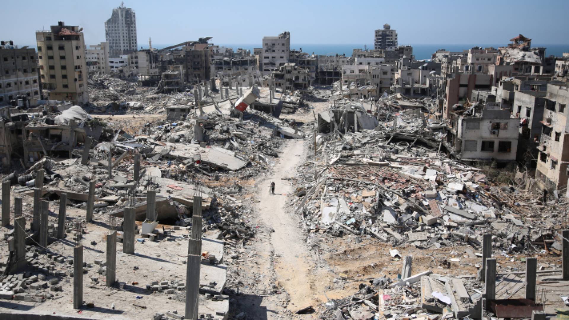 فلسطيني يسير بين أنقاض المباني حول مستشفى الشفاء في غزة