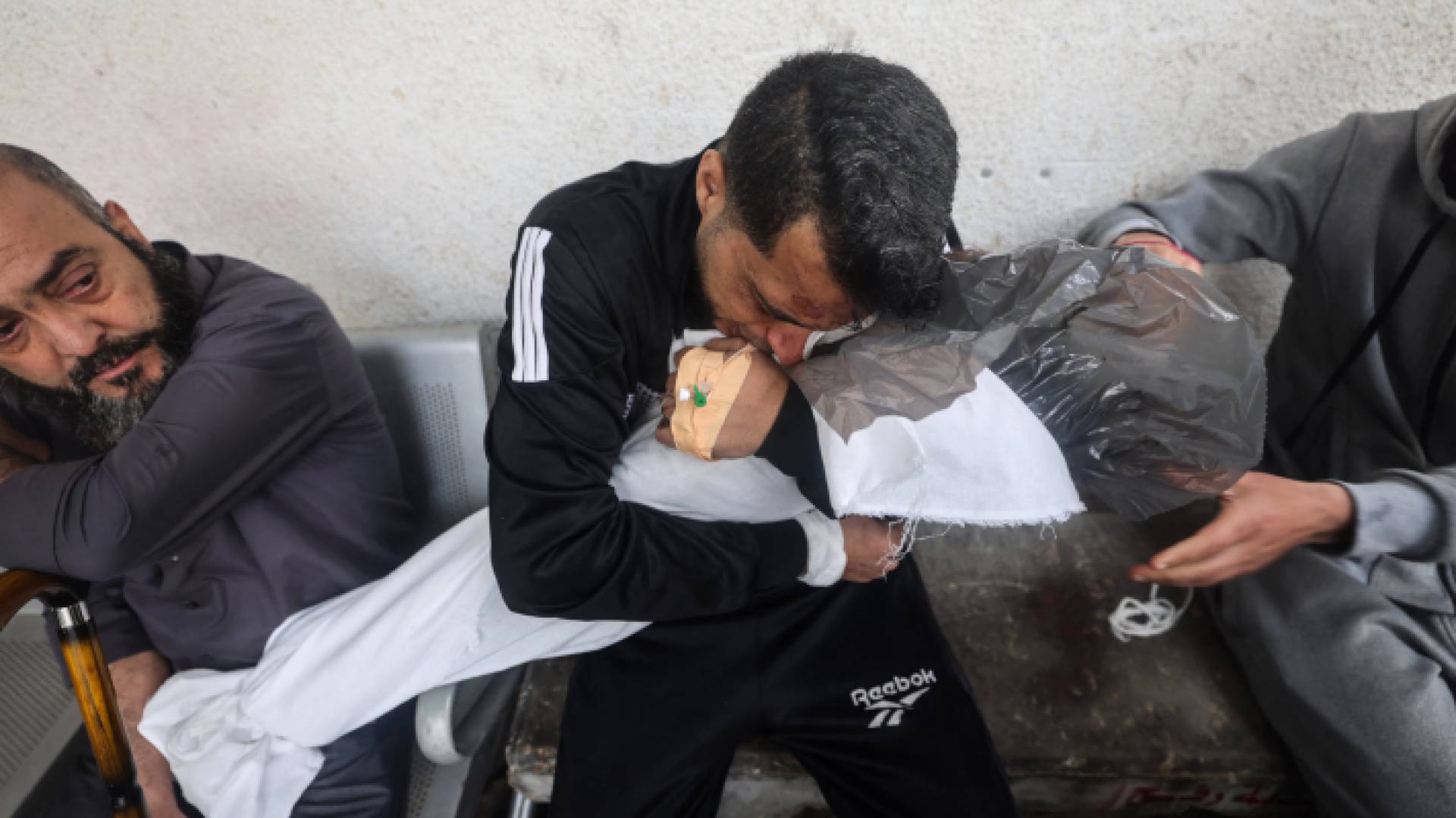 أب فلسطيني يحمل طفله الشهيد في مستشفى النجار في رفح، جنوب القطاع غزة