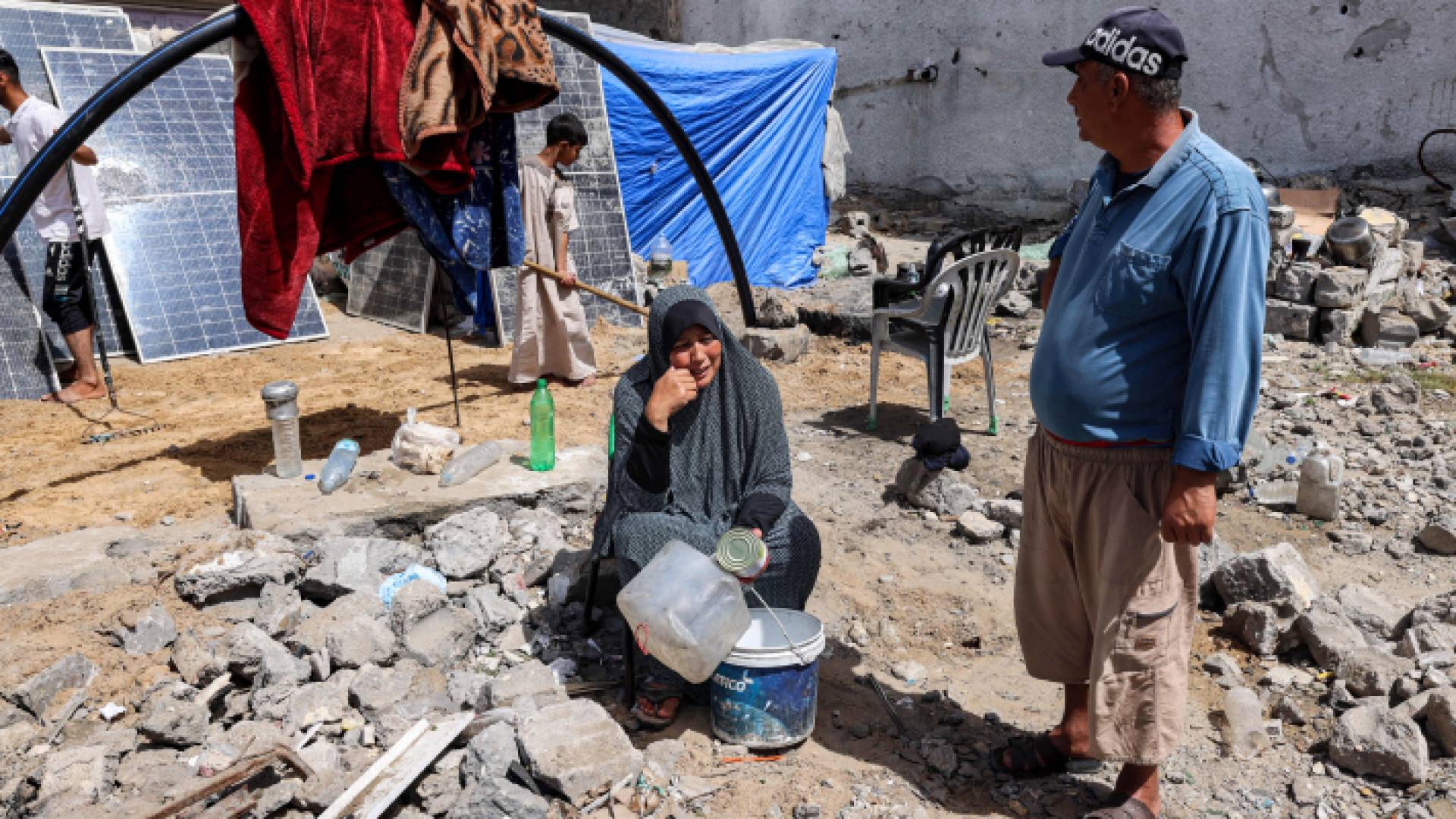 فلسطينيون وسط الدمار في قطاع غزة