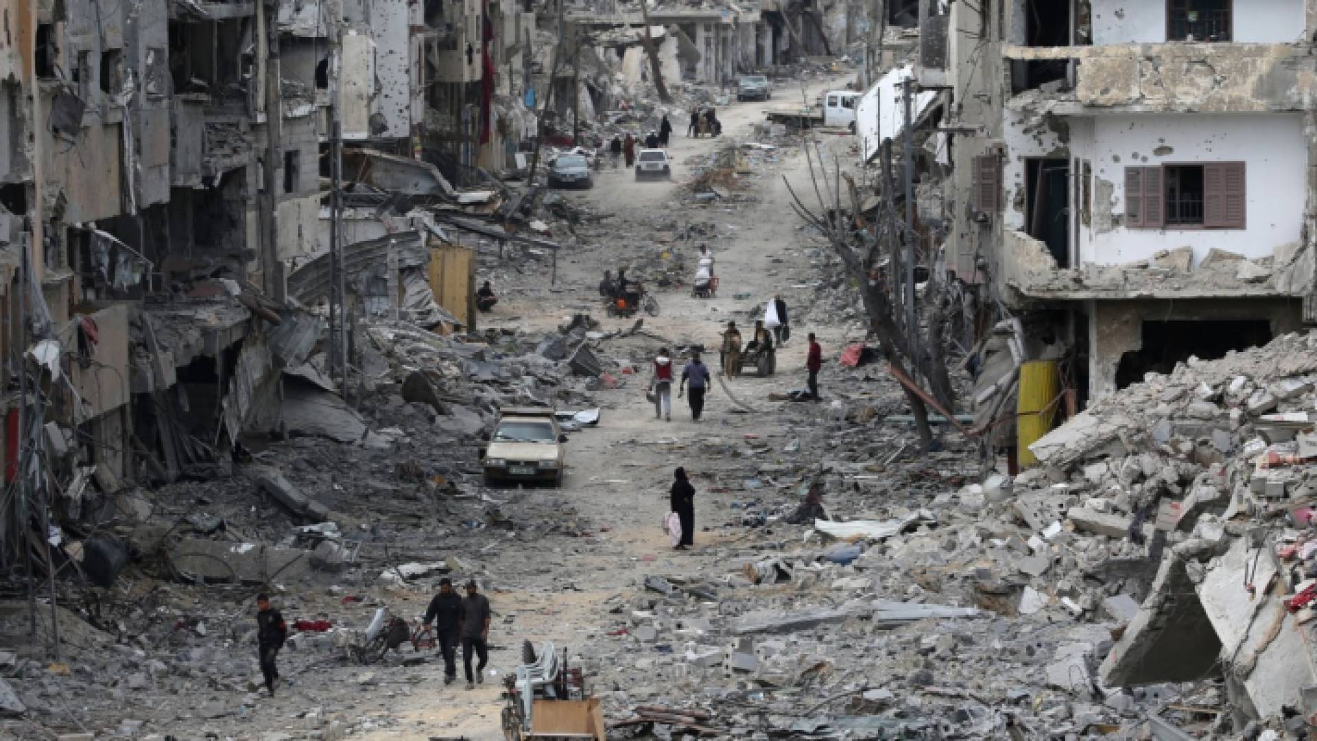 فلسطينيون يسيرون في مدينة خان يونس بعد انسحاب الاحتلال منها - AFP