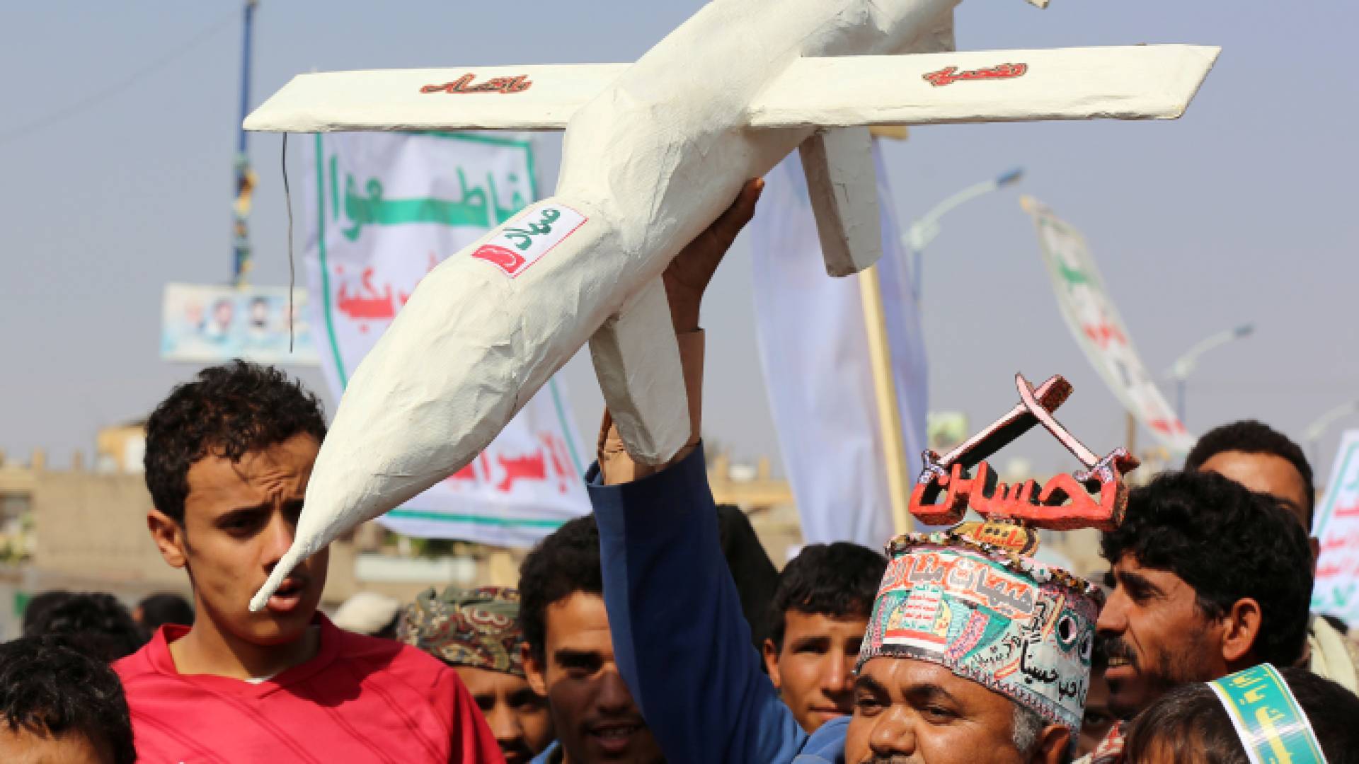 مناصرو الحوثيين يرفعون مجسم لإحدى الطائرات بدون طيار التابعة للجماعة