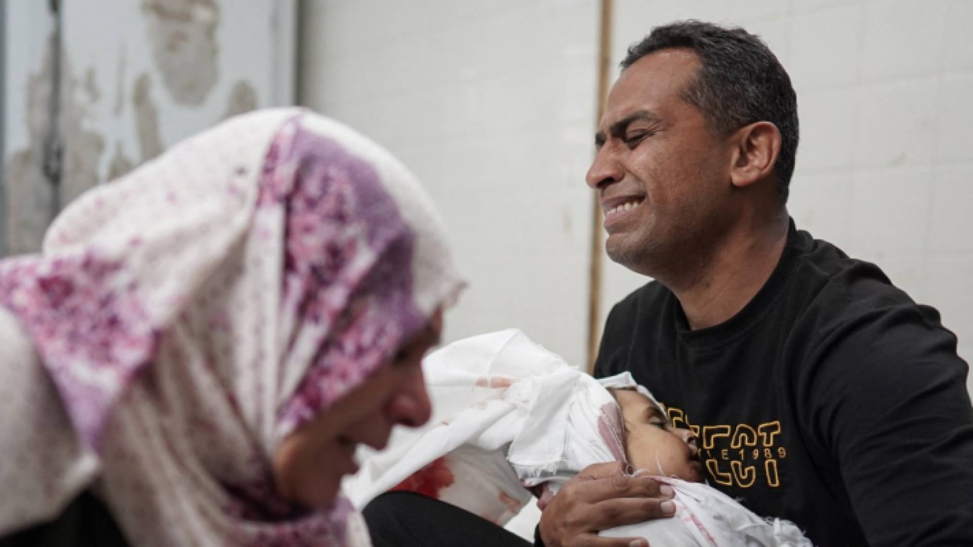 فلسطيني يودع طفله في غزة