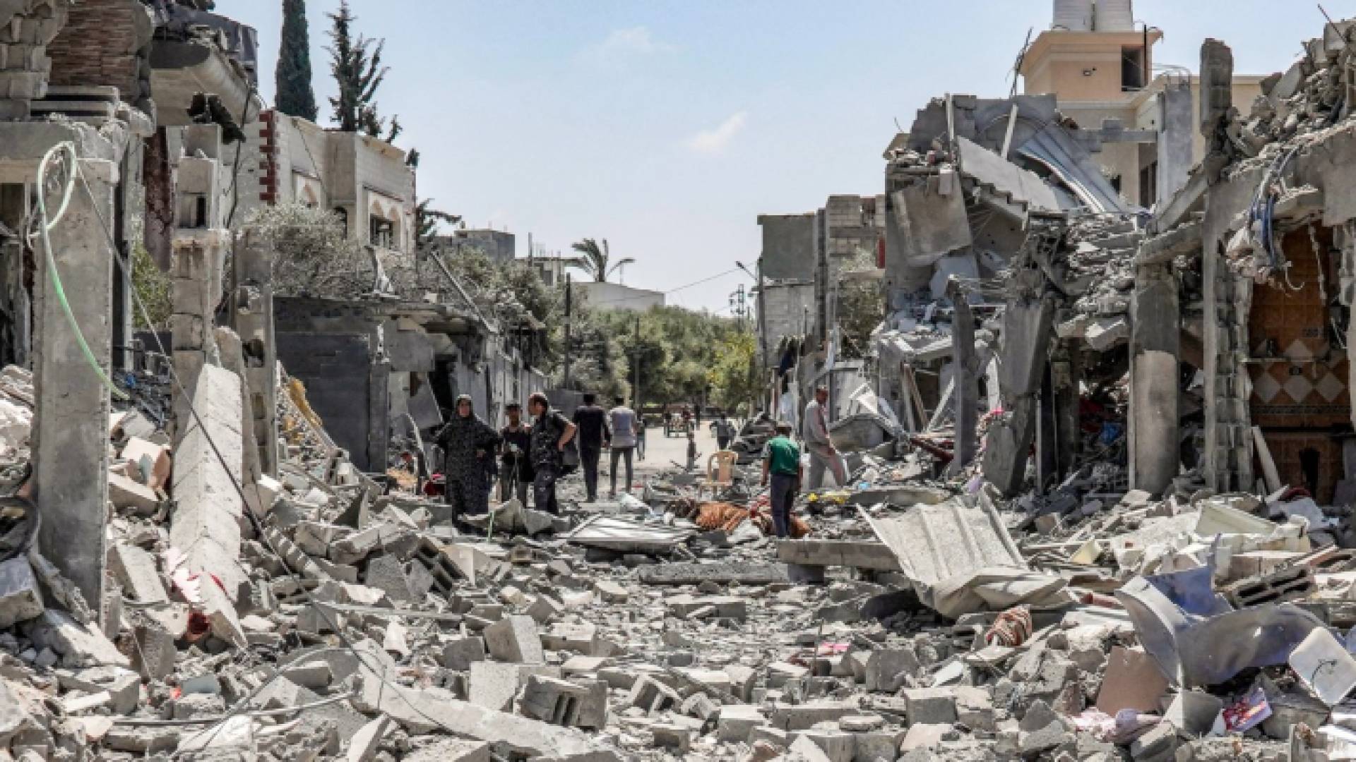 فلسطينيون يبحثون بين أنقاض مبنى منهار في الجانب الشرقي من مخيم المغازي