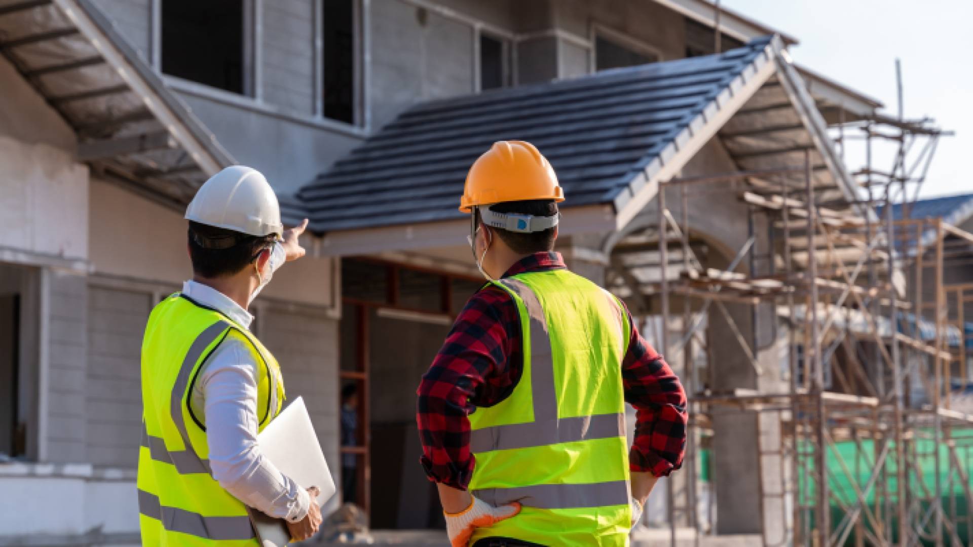 مهندسان يقفان أمام منزل قيد الإنشاء