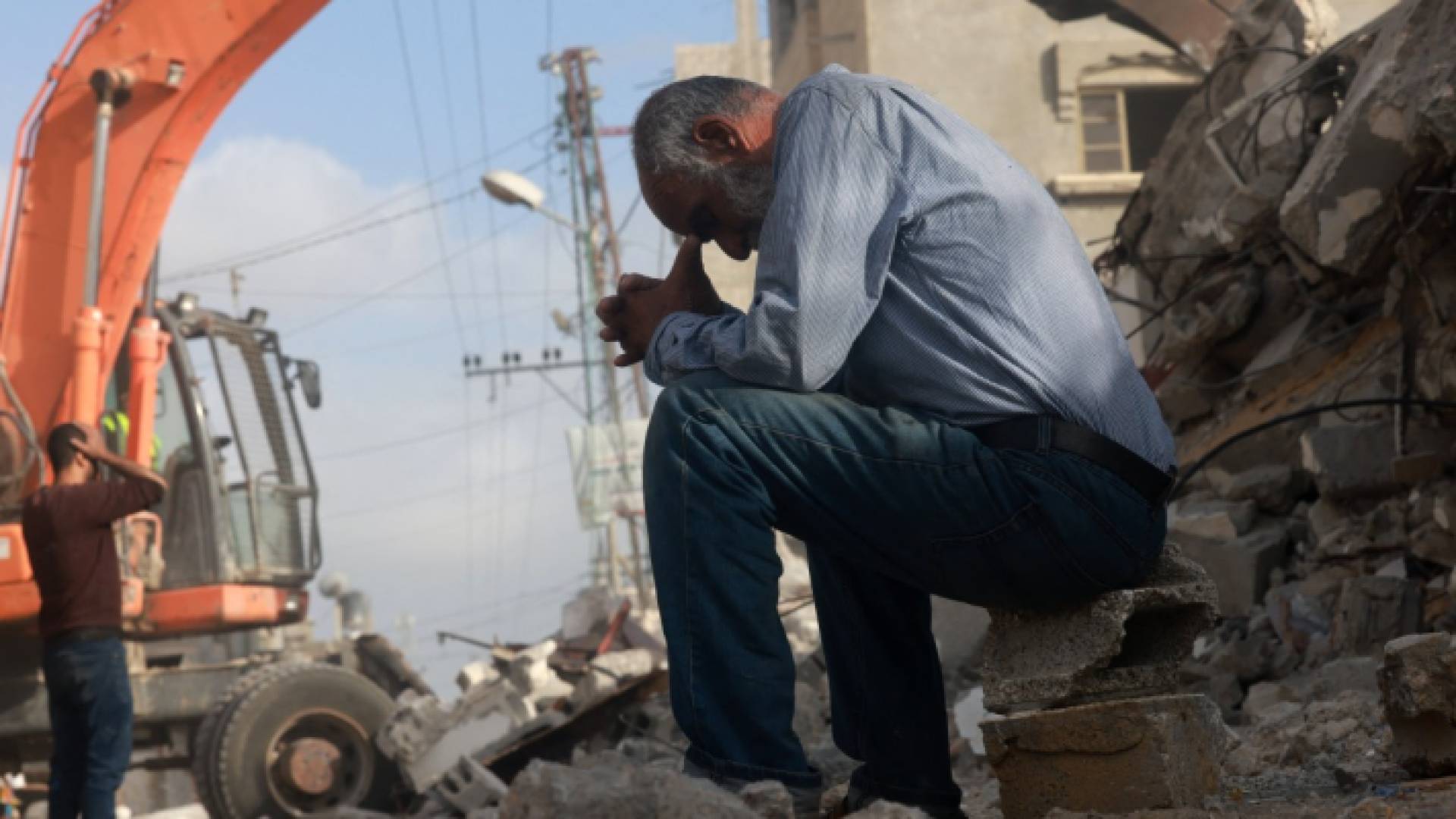 رجل ينتظر أخبارا عن ابنته بينما يبحث عمال الإنقاذ عن ناجين تحت أنقاض مبنى قصفه الاحتلال برفح