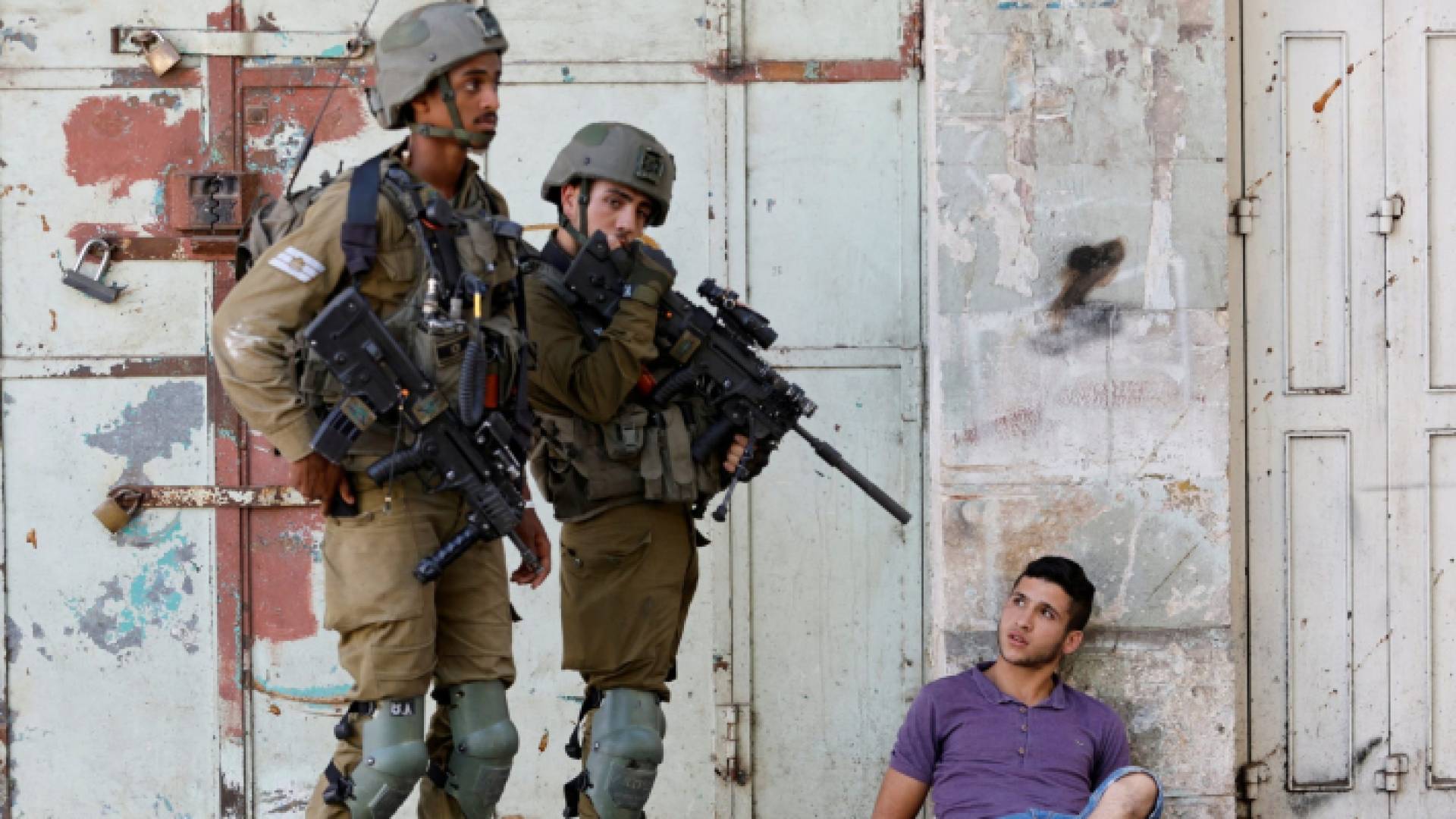 عناصر من قوات الاحتلال يرفعون سلاحهم صوب فلسطيني - أرشيفية