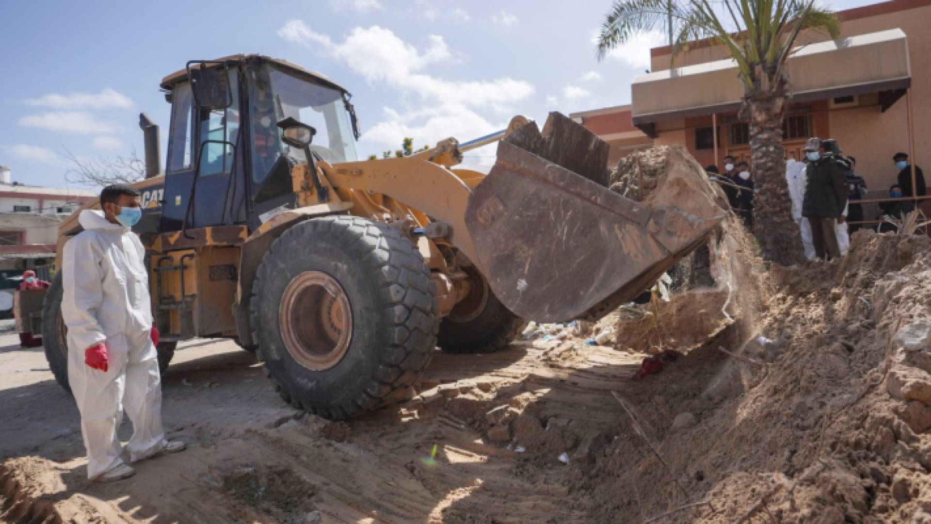 عاملون صحيون فلسطينيون ينقبون عن الجثث المدفونة في مجمع مستشفى ناصر في خان يونس