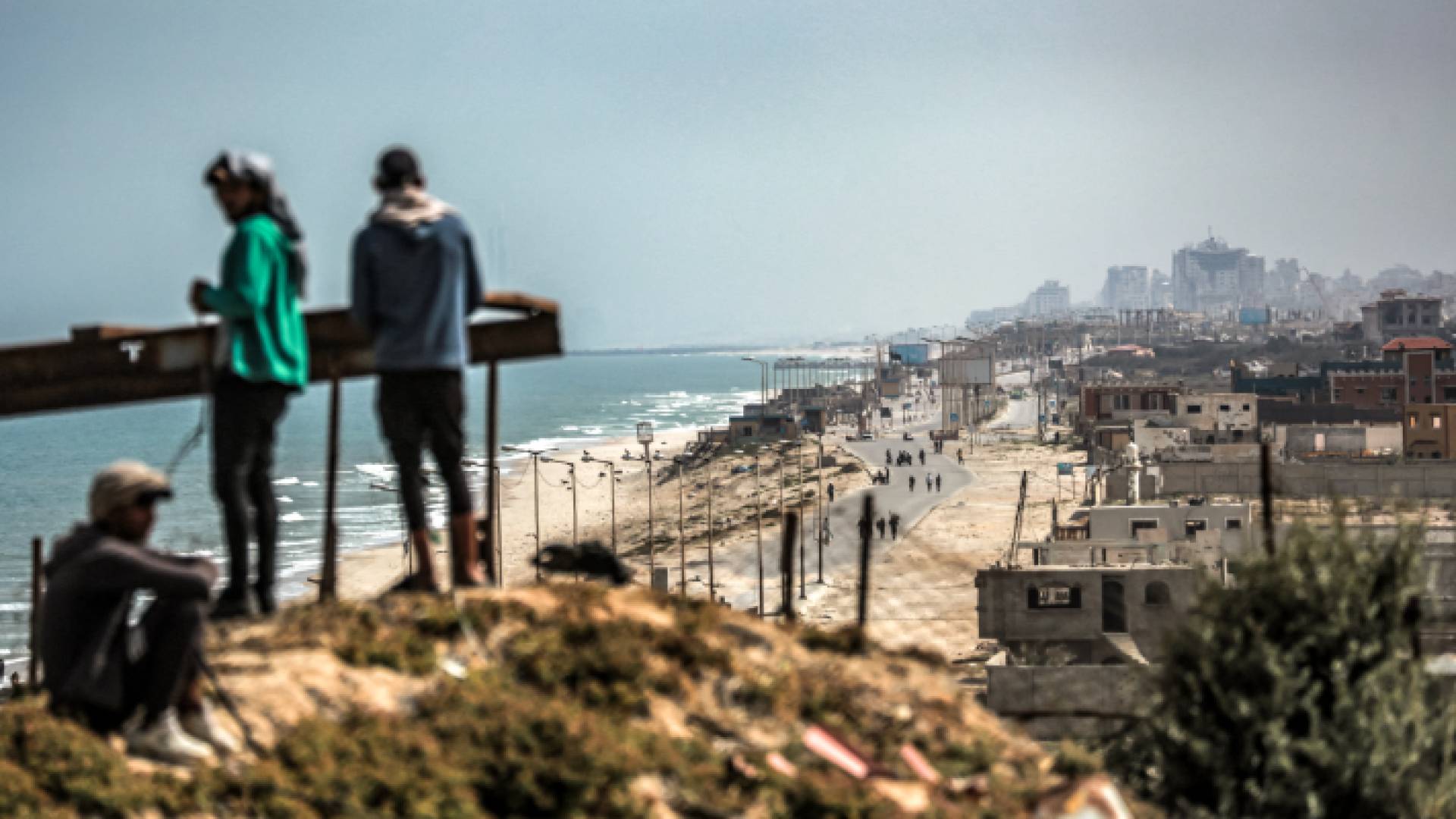 فلسطينيون يقفون فوق منطقة مرتفعة في الزهراء وسط قطاع غزة - AFP