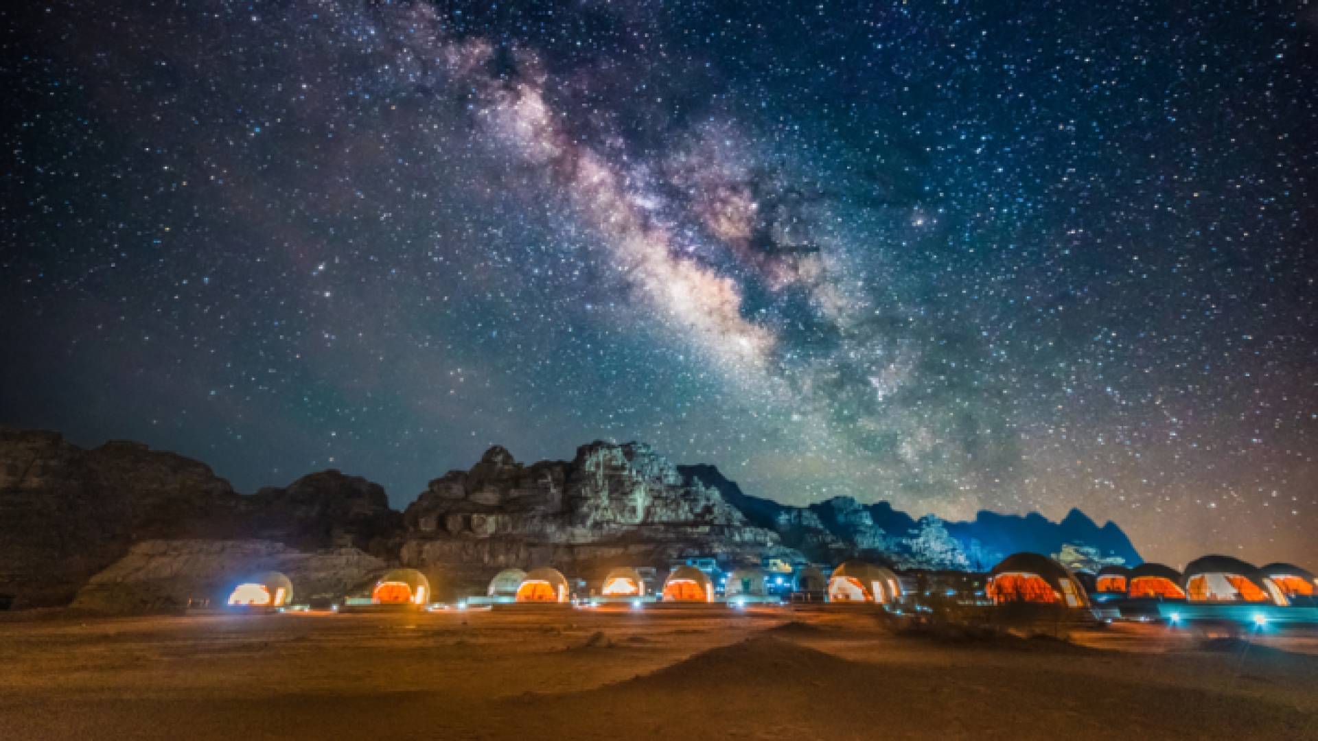 مشهد لأحد مخيمات صحراء وادي رم بالتزامن مع صورة للنجوم في السماء