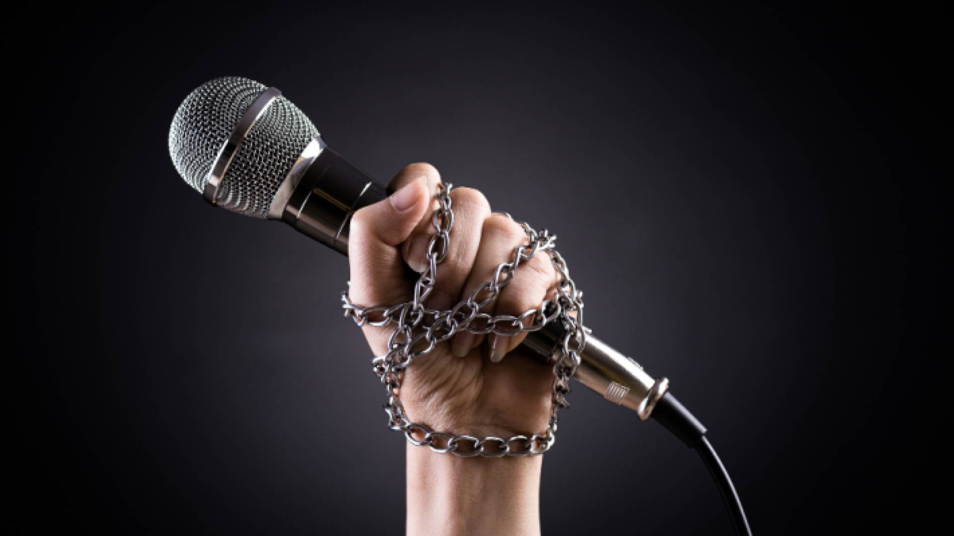 شخص مكبل اليدين يحمل ميكروفون تعبيرية عن حرية الصحافة