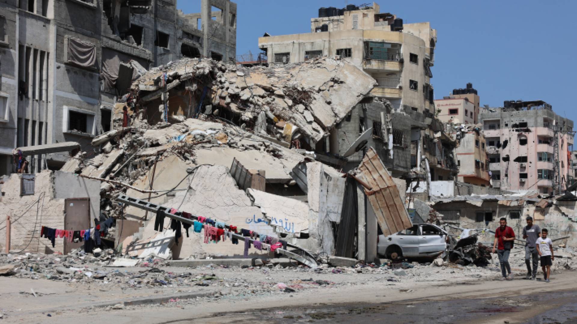 فلسطينيون وسط الدمار الذي خلفه الاحتلال في قطاع غزة