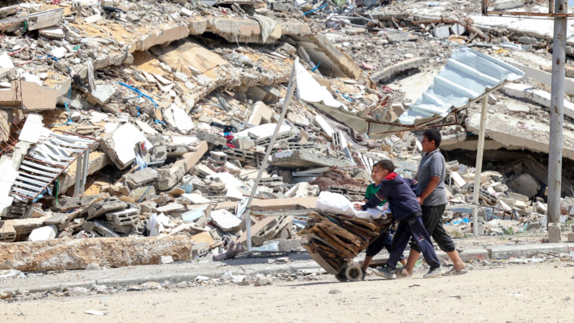 أطفال يسيرون وسط الدمار في أحد شوارع غزة