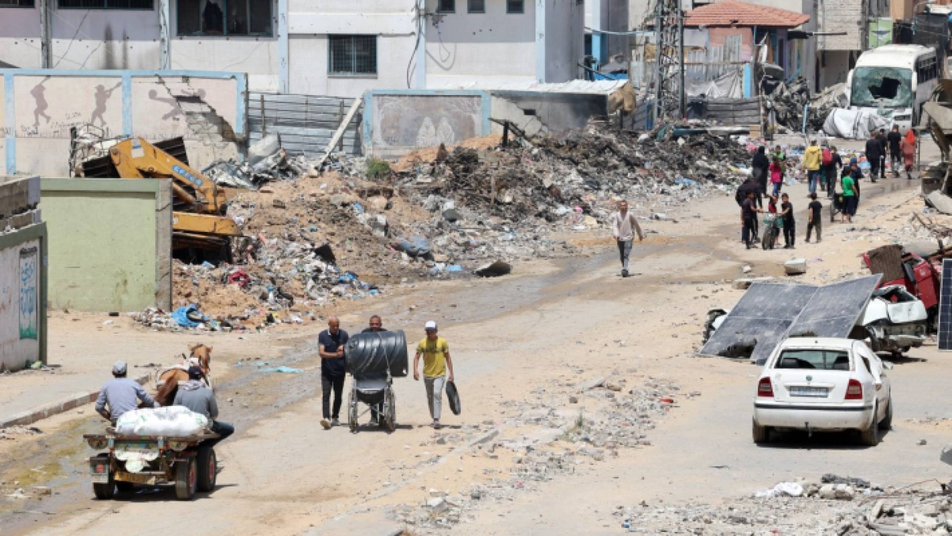فلسطينيون يسيرون مع ممتلكاتهم في بيت لاهيا في شمال قطاع غزة