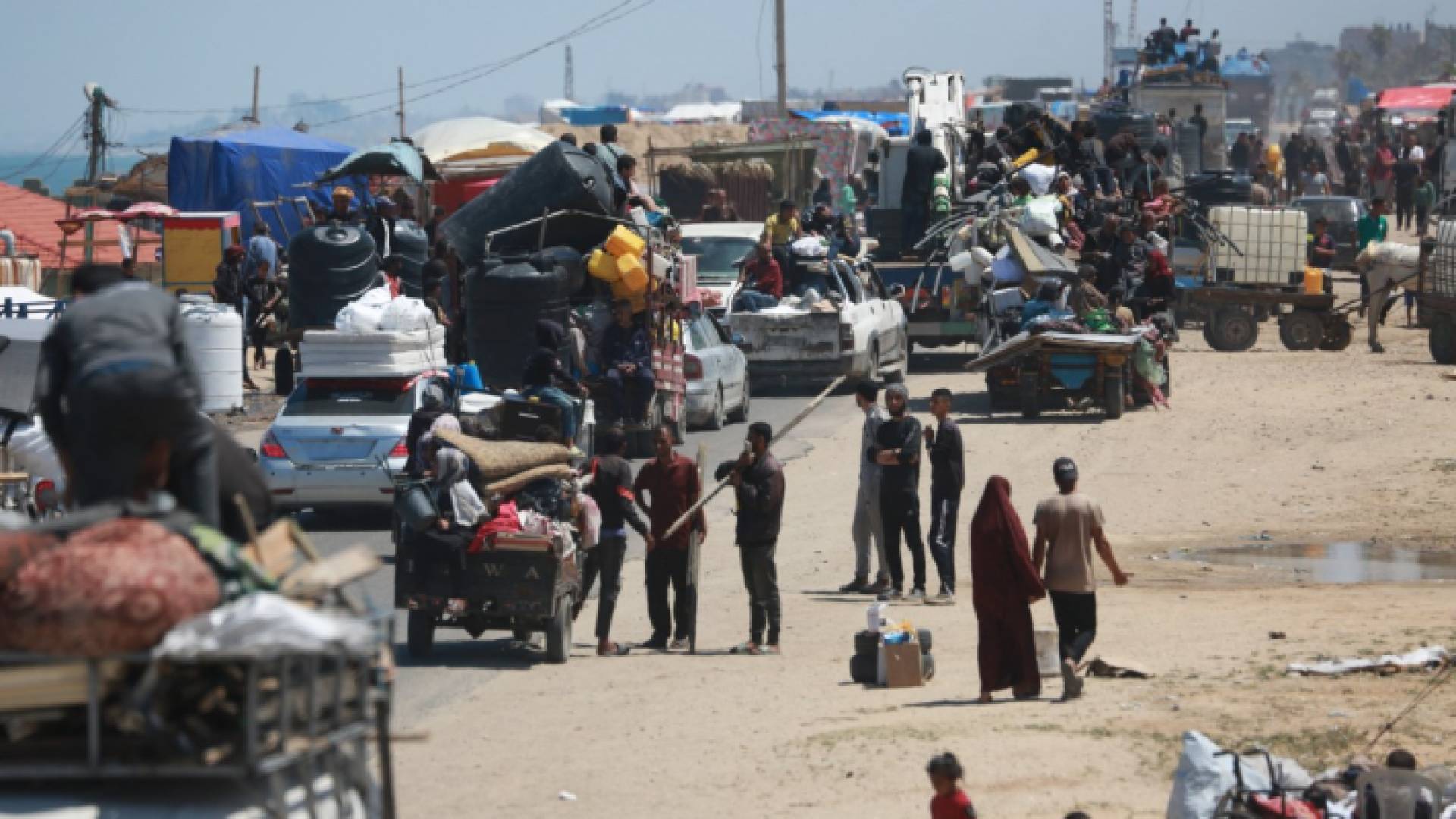 نازحون فلسطينيون يصلون مع أمتعتهم لإقامة خيام على الشاطئ بالقرب من دير البلح