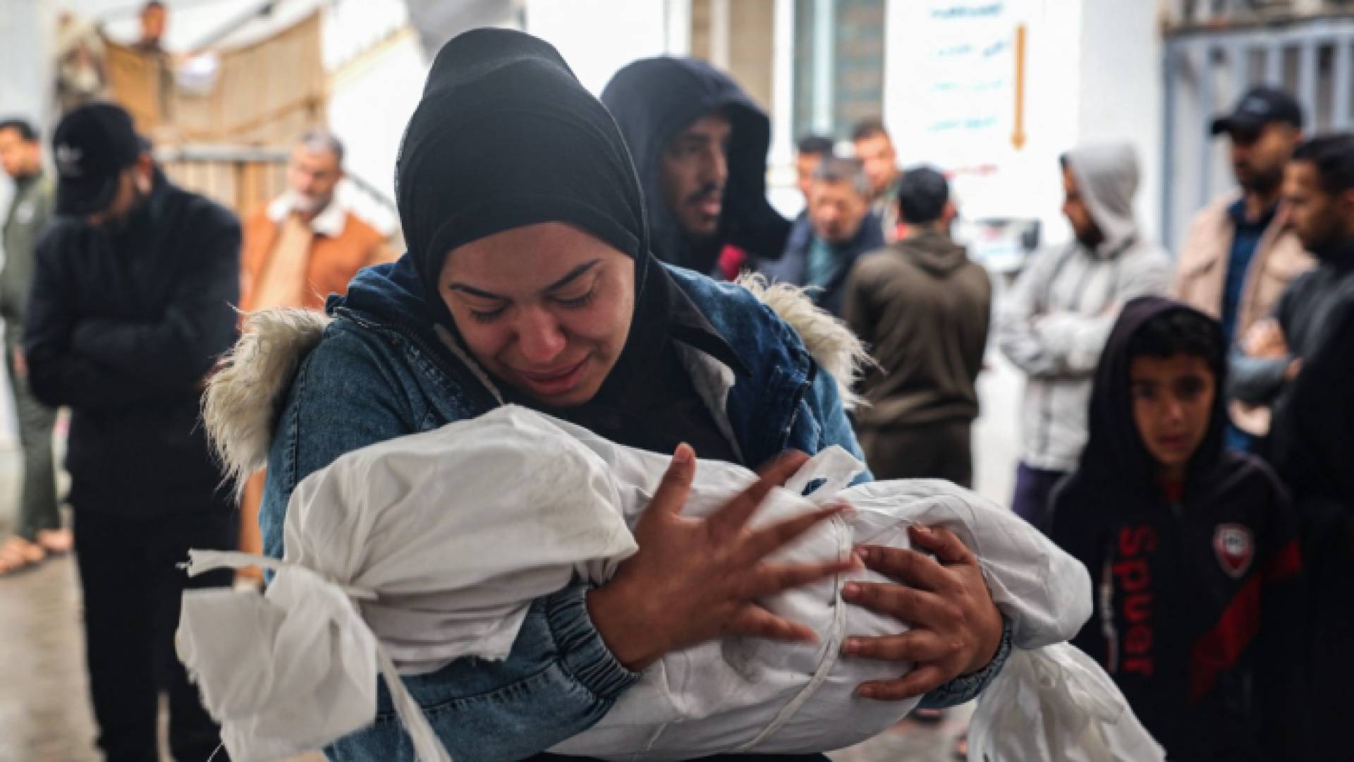 سيدة فلسطينية تحمل جثمان طفلها