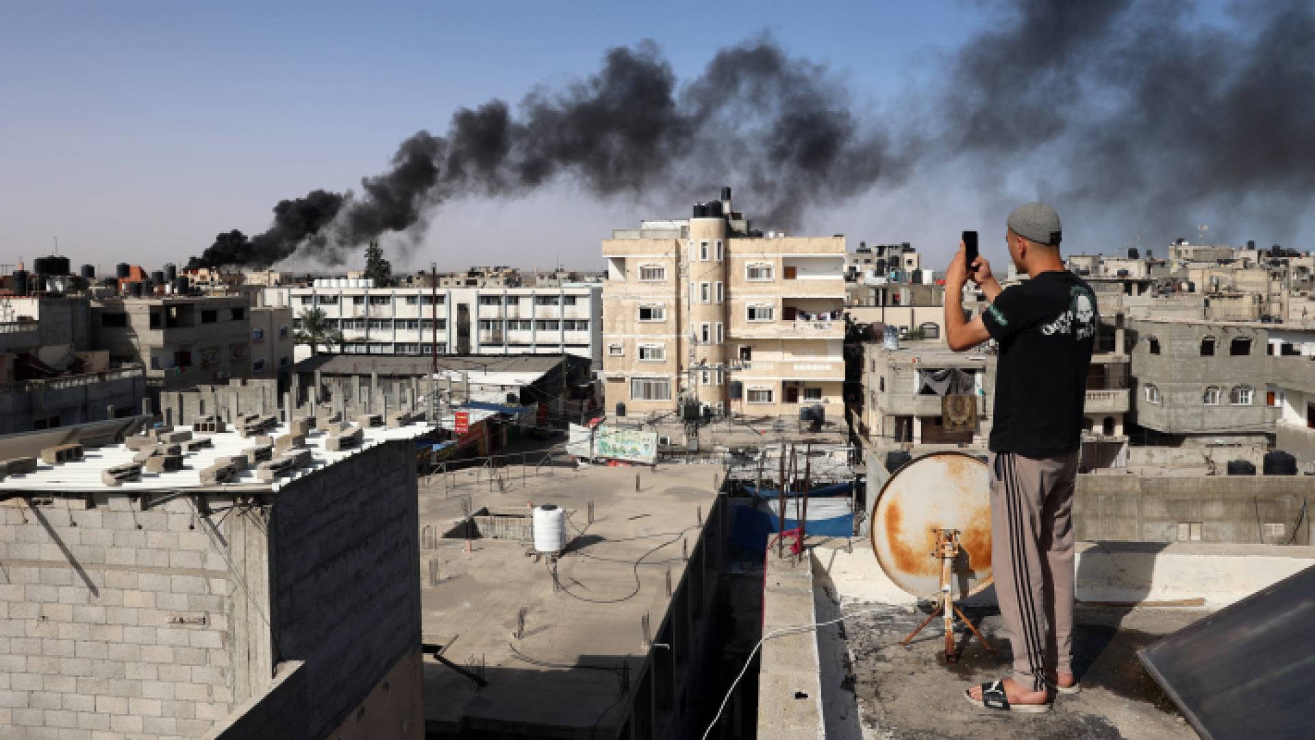 شاب فلسطيني يلتقط صورا لقصف الاحتلال في رفح بجنوب قطاع غزة