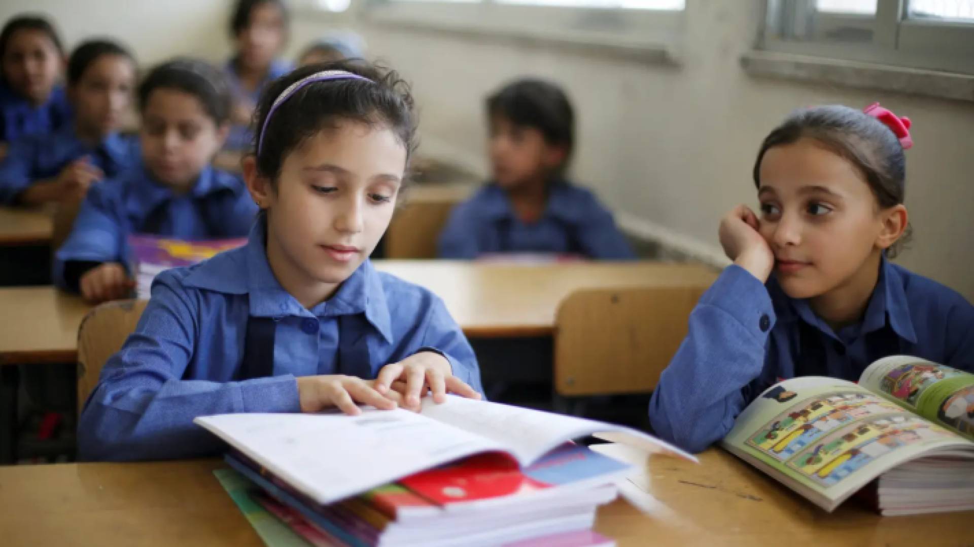 طالبتان يتصفحان منهاج اللغة الإنجليزية في الأردن - أرشيفية