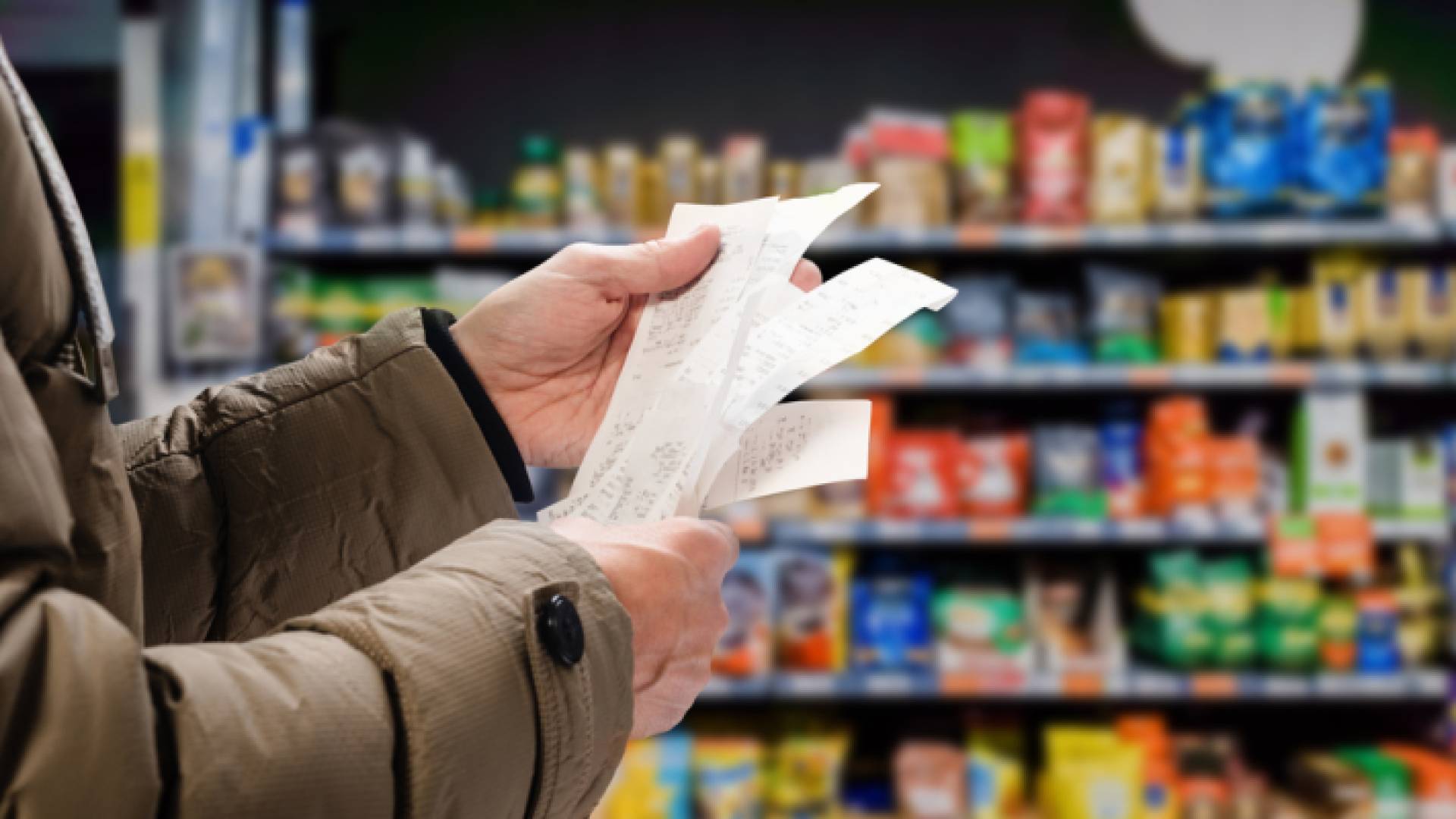 رجل يحمل إيصالات في السوبر ماركت ويتتبع الأسعار