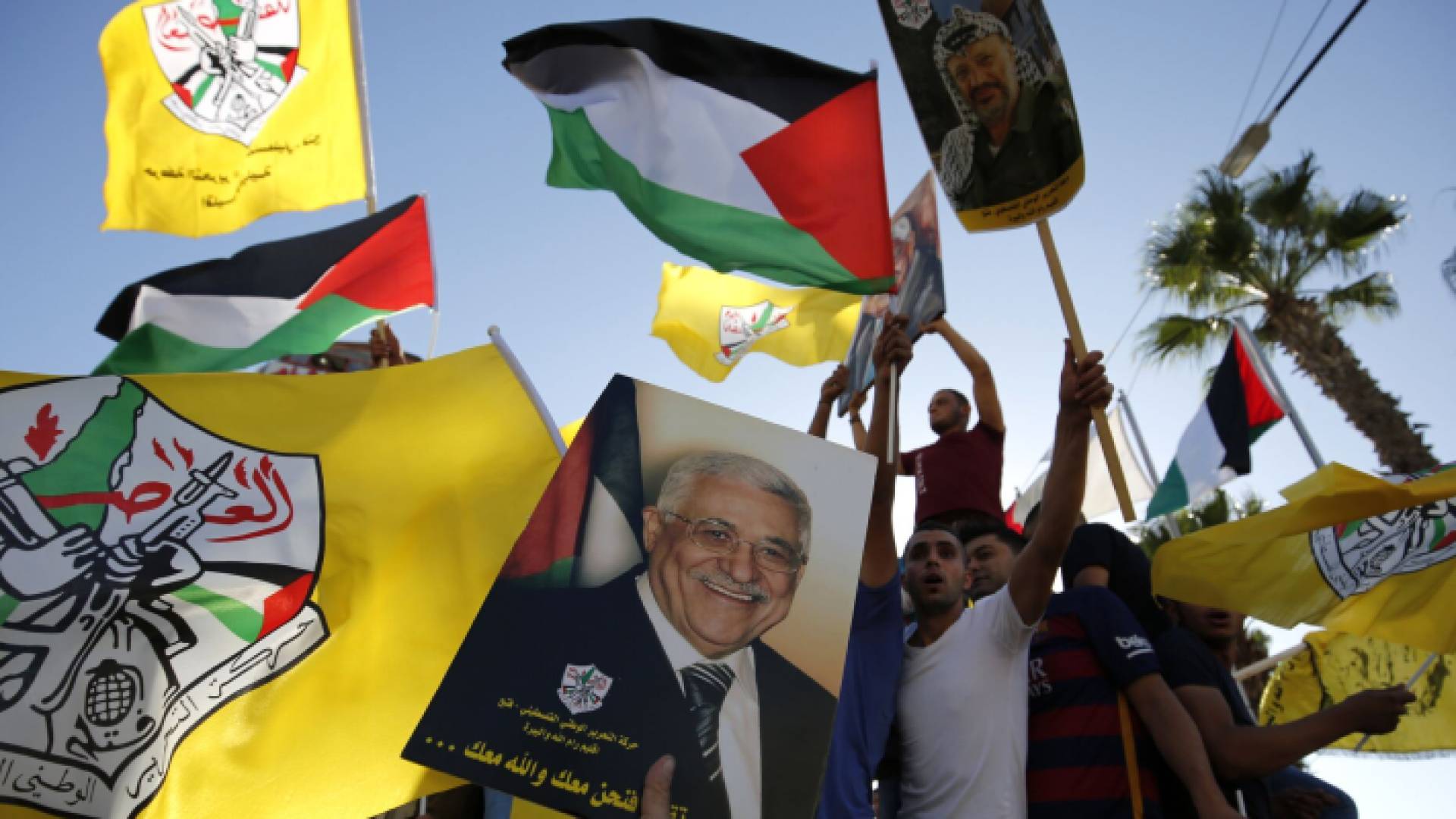 فلسطينيون يرفعون الأعلام الفلسطينية وأعلام حركة فتح