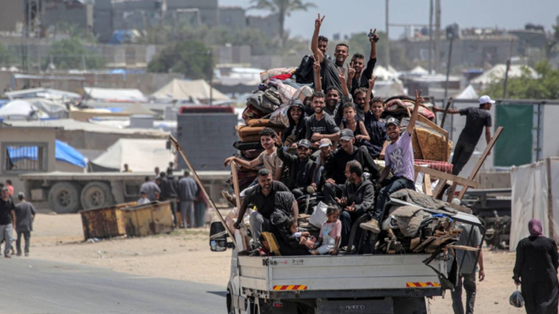 فلسطينيون نزحوا من رفح في جنوب قطاع غزة يركبون مع أمتعتهم في الجزء الخلفي من شاحنة