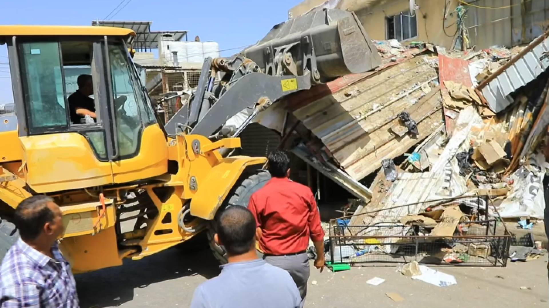 جرافة تعمل على إزالة الاعتداءات على الأرصفة في مخيم الوحدات