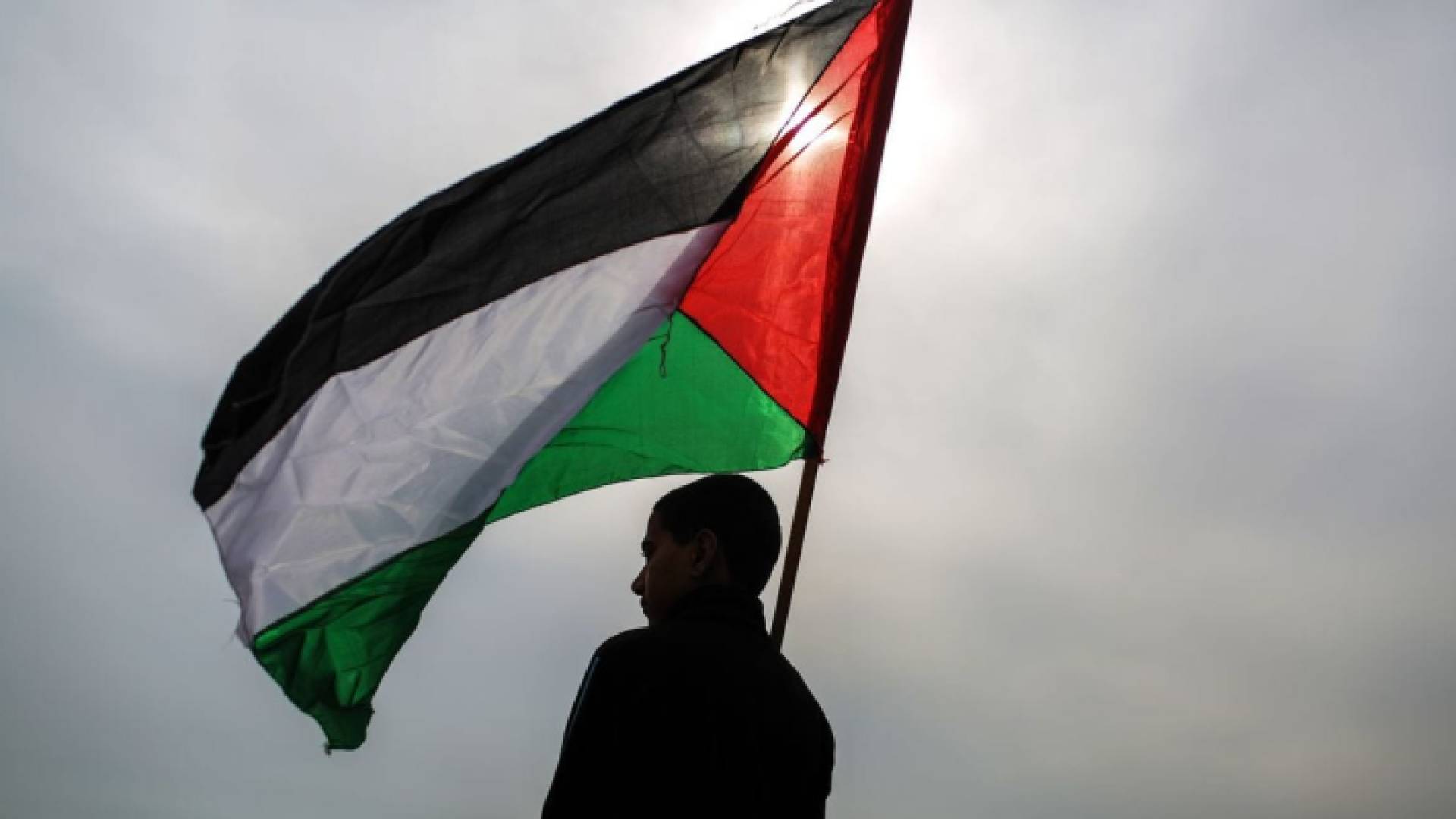 رجل يرفع العلم الفلسطيني