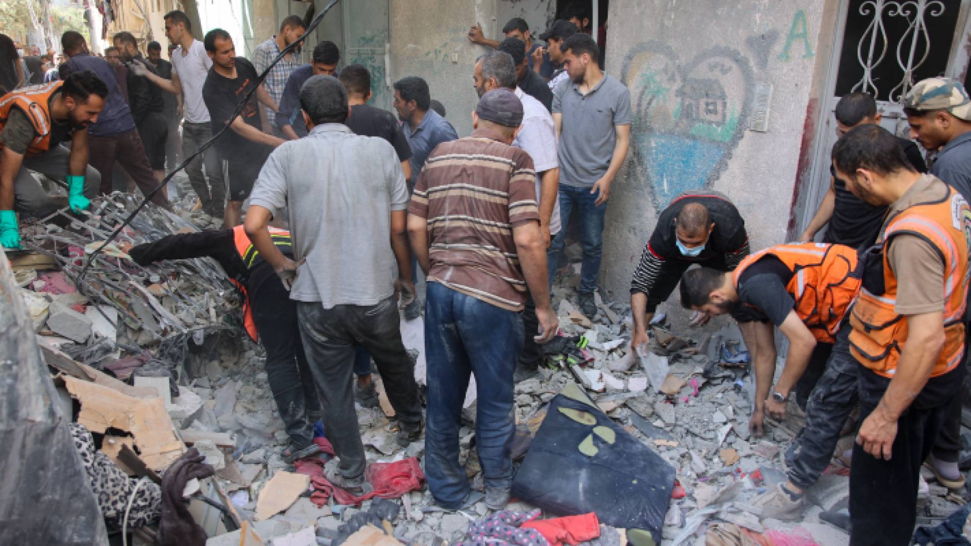 فلسطينيون يبحثون عن ناجين بين أنقاض مبنى تضرر خلال قصف الاحتلال حي الدرج في مدينة غزة - AFP