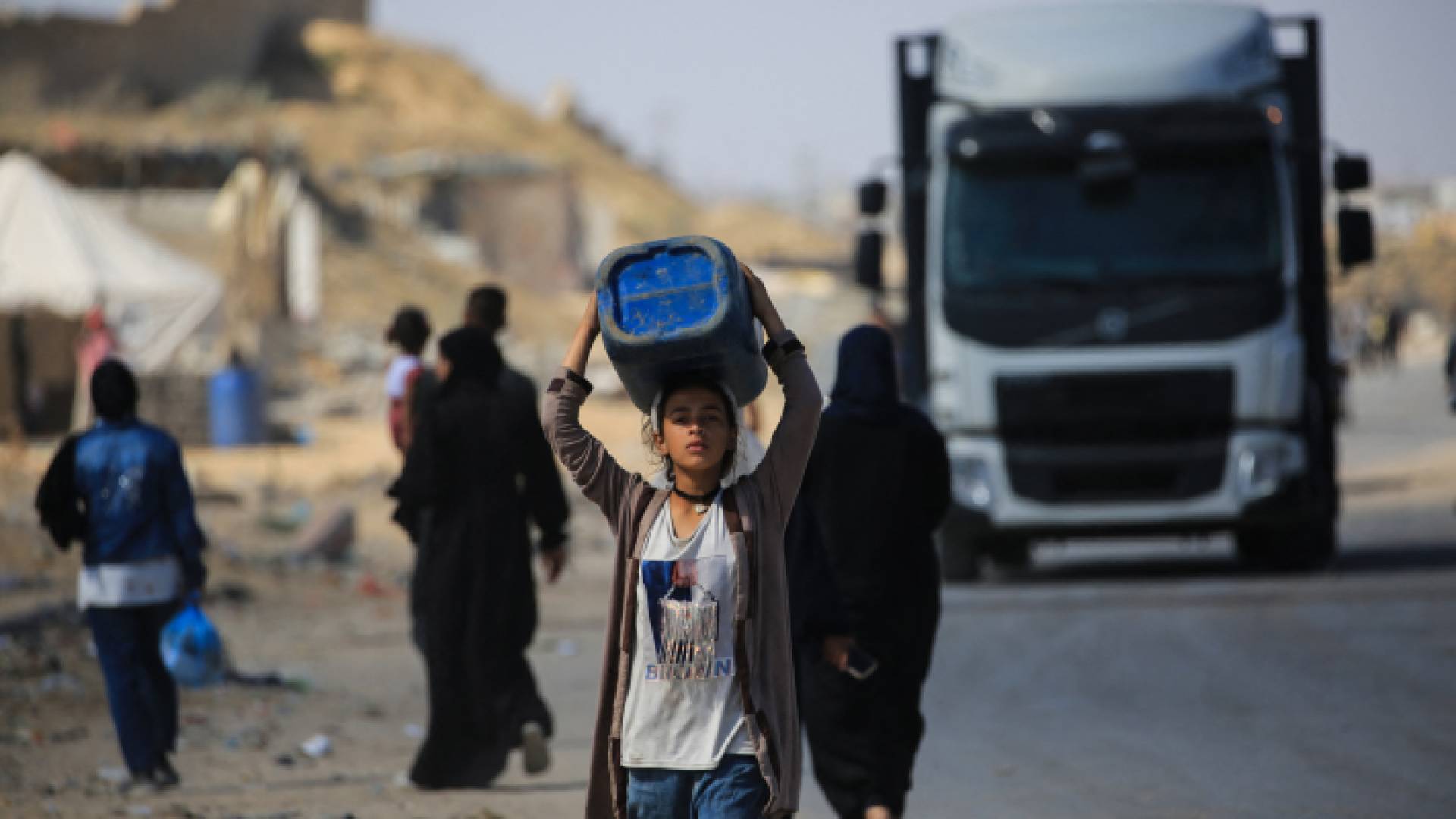 فتاة في غزة تحمل "جالون" ماء على رأسها