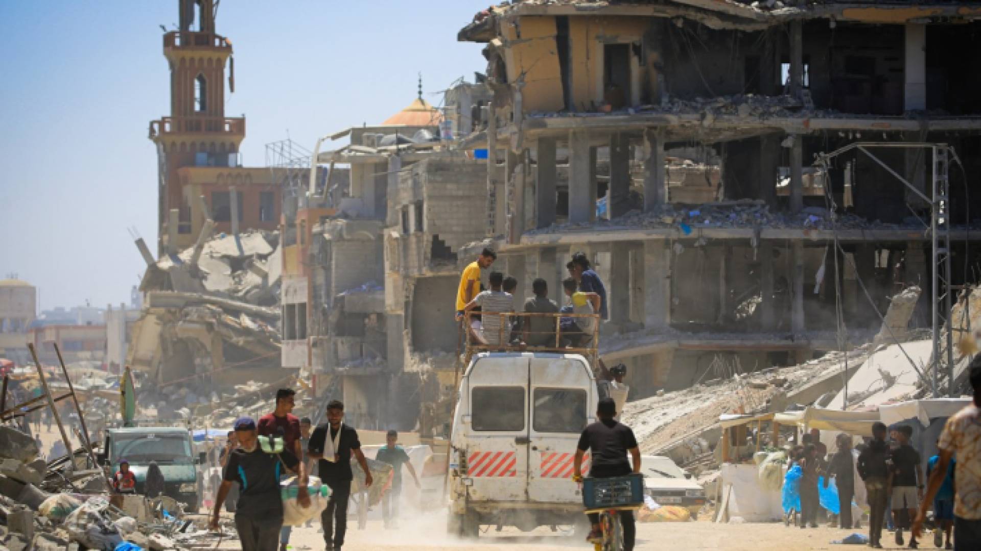 نازحون فلسطينيون يسيرون في شارع مدمر في خان يونس بجنوب قطاع غزة