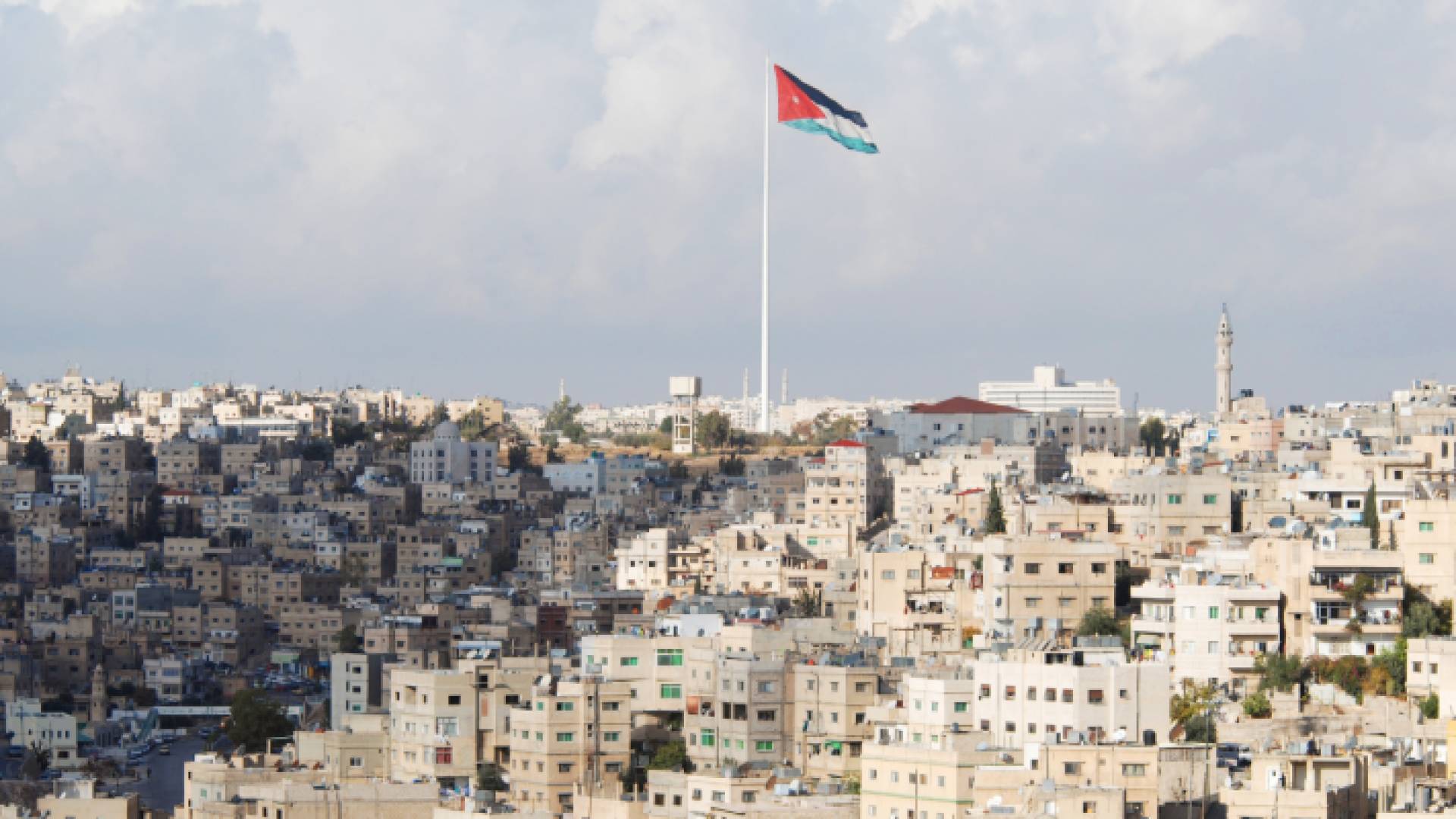 صورة تظهر منطقة وادي الحدادة مع مشهد مهيب لسارية العلم الأردني